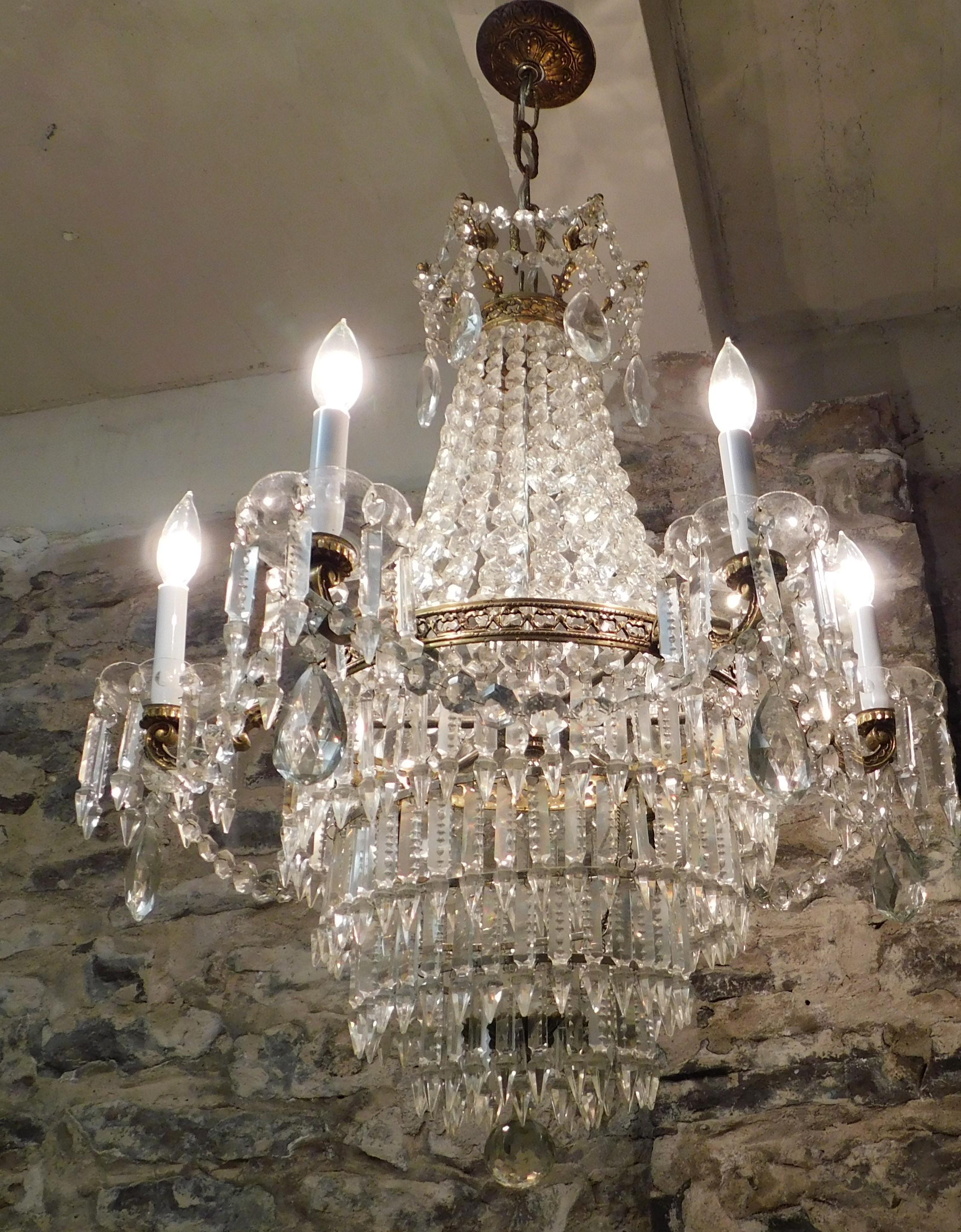 Beautiful ornate large circa 1910 French bronze multi sized and shaped crystal tiered chandelier. Actual chandelier size is 31 inches high plus another 12 inches of chain to the canopy ceiling top and 27 inches round.