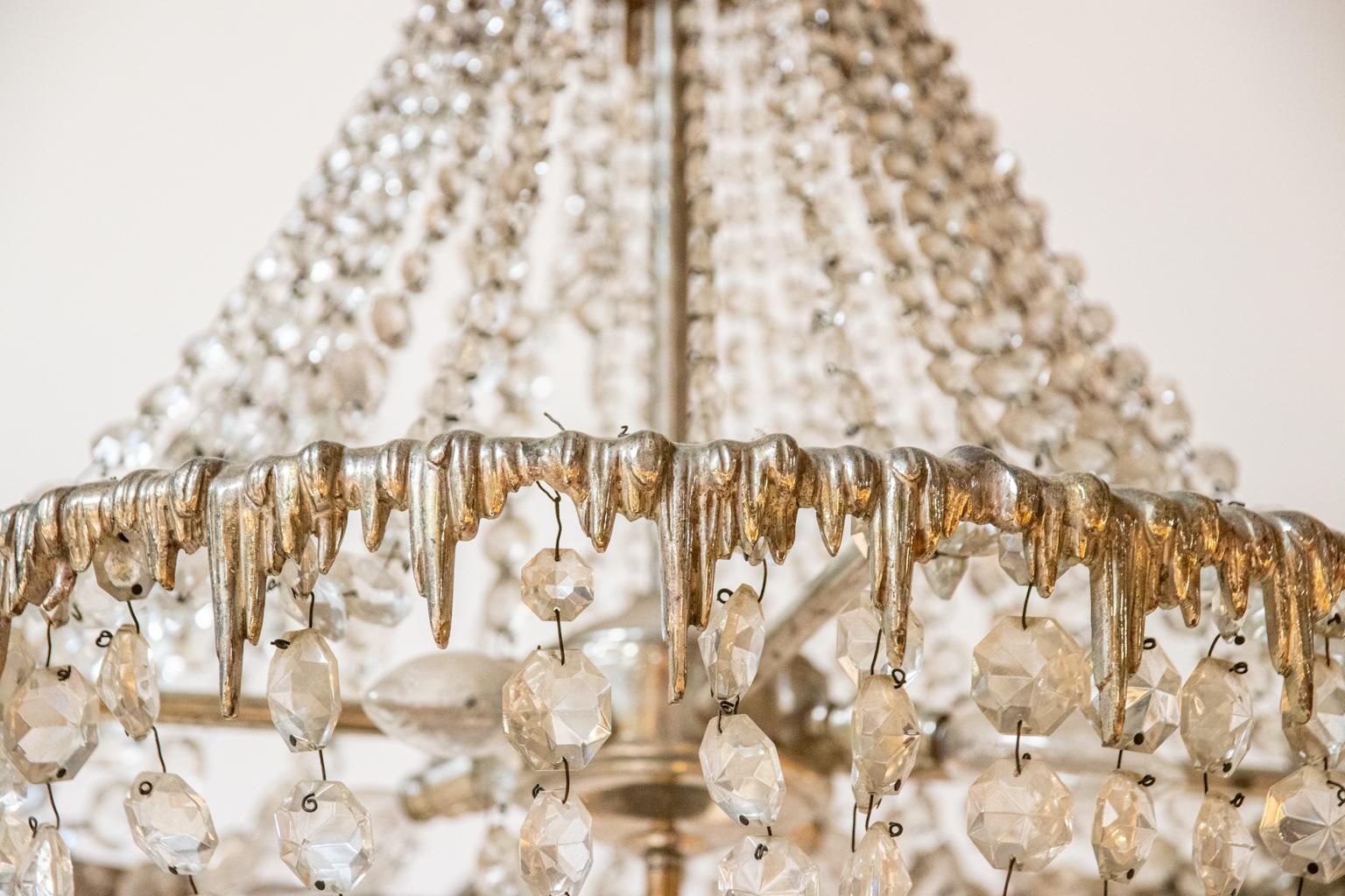 French two tier crystal chandelier with pendant metal drops throughout the circumference of the circular frame in the shape of icicles. The chandelier is further detailed with strands of crystal bead swags. Please note of wear consistent with age