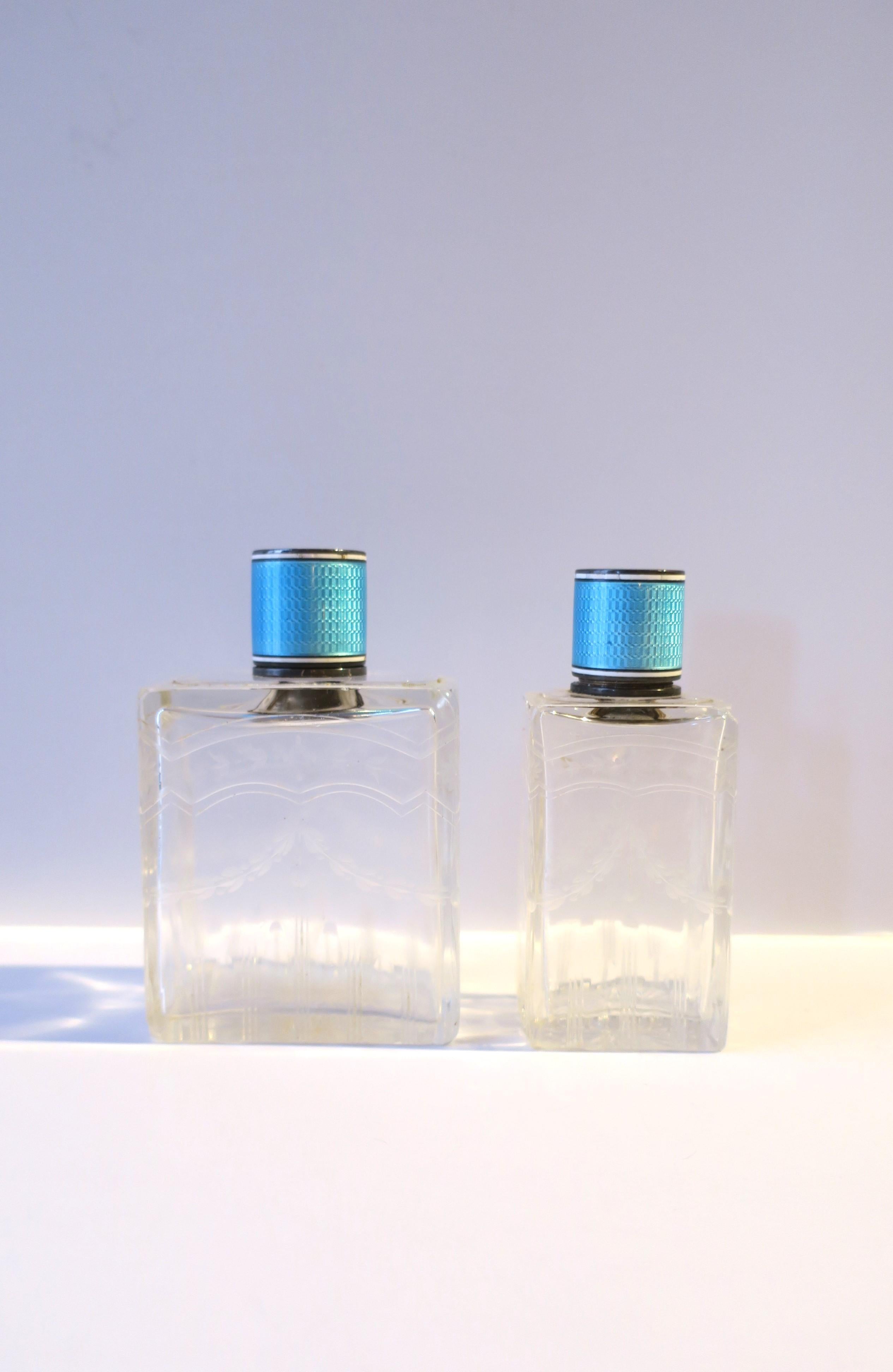 A pair/set of two (2) French crystal, sterling silver, and light blue guilloche enamel topped vanity bottles, circa late-19th century to early-20th century, France. Bottle tops are a beautiful sterling silver and light blue and white guilloche