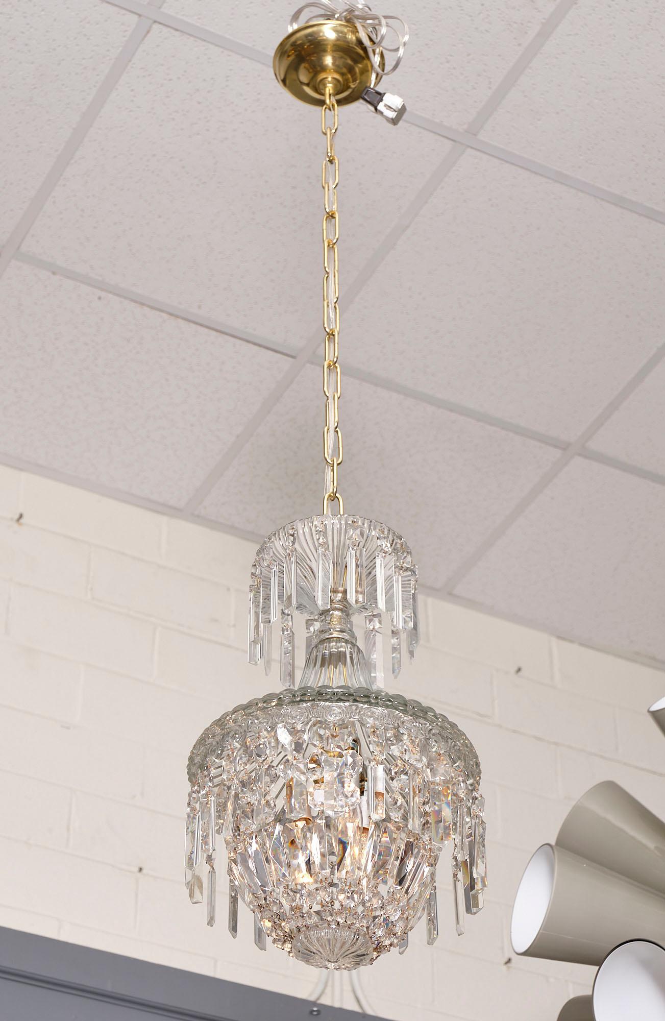 French crystal antique chandelier in the manner of Baccarat with cut crystal pendants around a crystal bell. This piece has been newly wired to fit US standards.