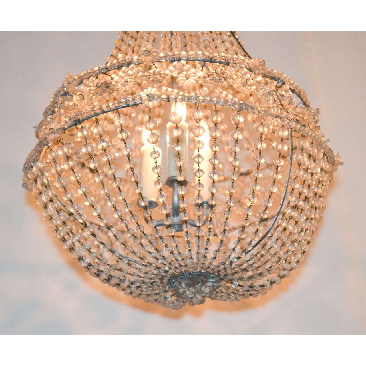 Lovely French crystal basket chandelier. The top with cascades of bead crystals leading to a central band accented with crystal rosettes. The basket-form base draped with multiple strands of bead cut crystals,

circa 1920.