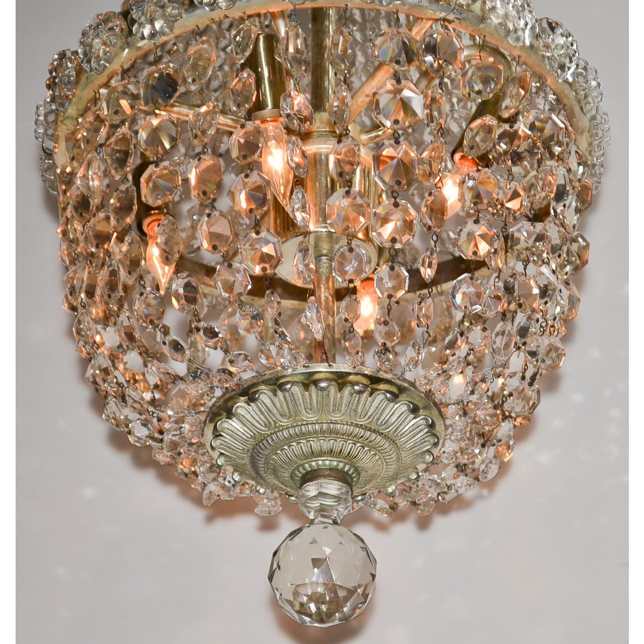 Gorgeous small scaled French bronze and crystal chandelier with a foliate motif cast bronze canopy above multiple strands of faceted bead crystals leading to a central band of crystal flower-head accents. The basket with larger draped bead crystal