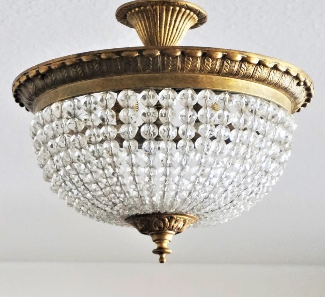 A lovely crystal beaded three-light ceiling fixture with gilt bronze crown shape frame, bottom and canopy, France, 1900-1910. This ceiling light can be used with canopy or can be mounted direct to the ceiling. Beautiful aged patina to bronze,