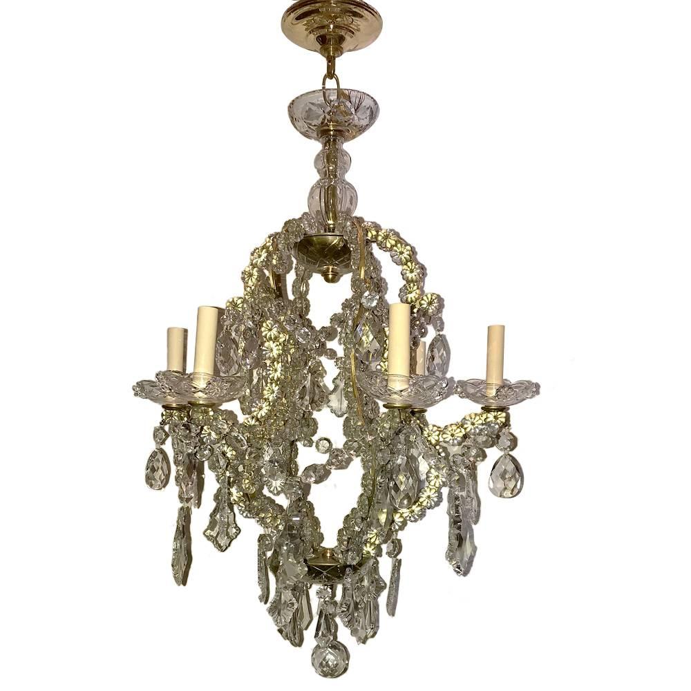 A French circa 1930s crystal chandelier with four lights. Gilt body covered with crystal rosettes. 

Measurements:
Height 28