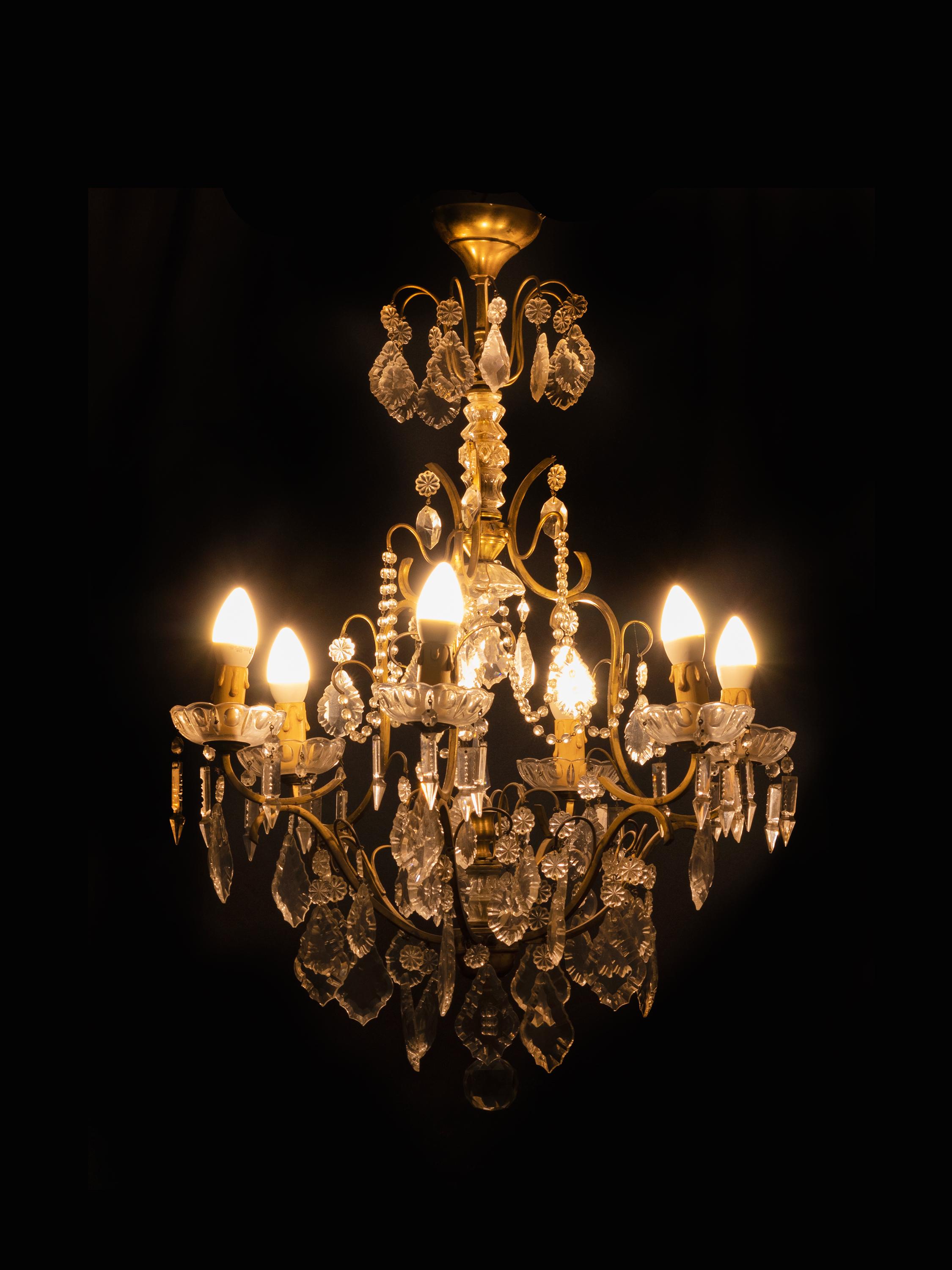 A Louis XV-Style bronze chandelier with crystal pendants and finials, completed and rewired.
Six arms with candlestick holders and six light sockets.

A superb piece of art and class.

The chandelier is currently wired for both European Union and US