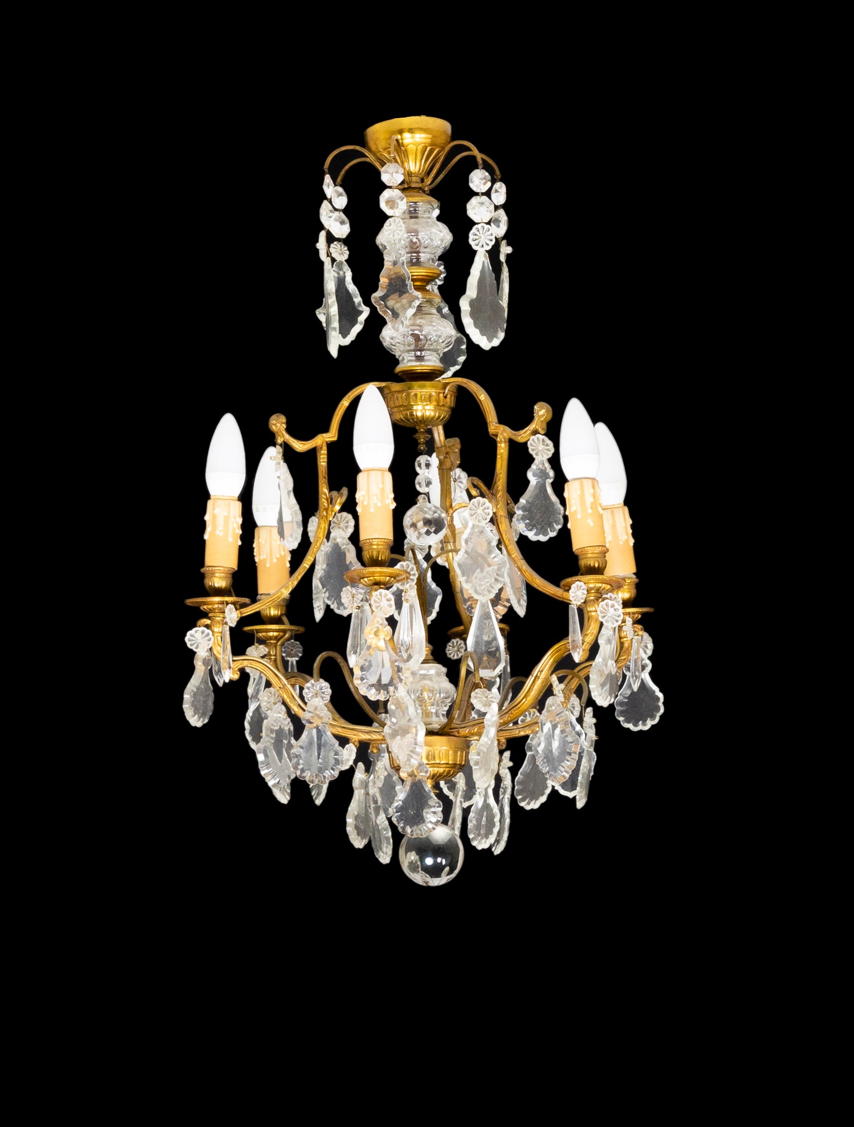 A Louis XV-Style bronze chandelier with twisted effect, glass pendants and finials, completed and rewired.
Six candlestick holders and six light sockets working. 

The chandelier is currently wired for both European Union and US standards LED
