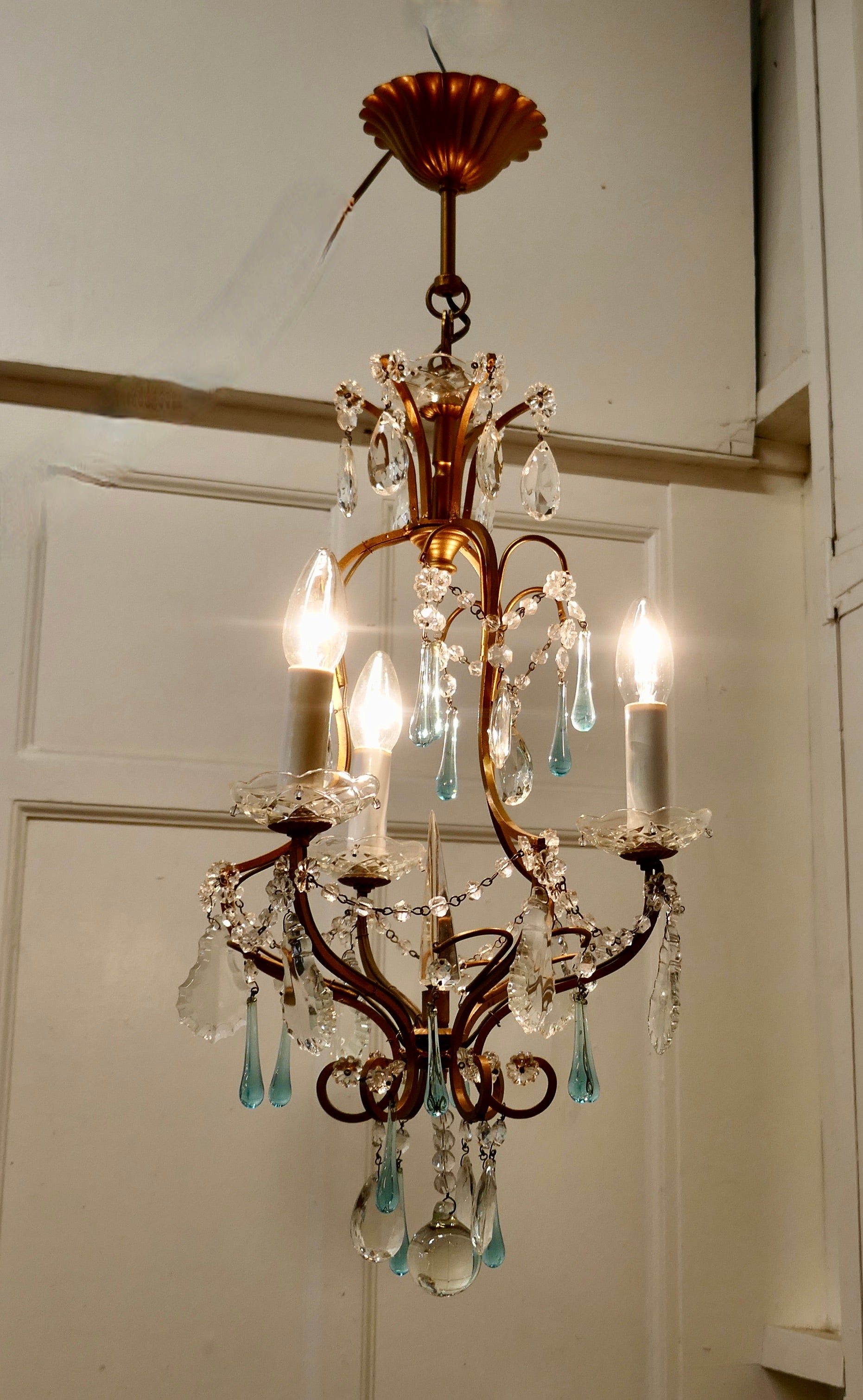 French Crystal Chandelier with Chains and Turquoise Drops

This is a very pretty and dainty piece, the brass has a gilded finish and 4 branches, the light is hung with beautiful Turquoise tear drops, and cut crystal flowers

The light is in good