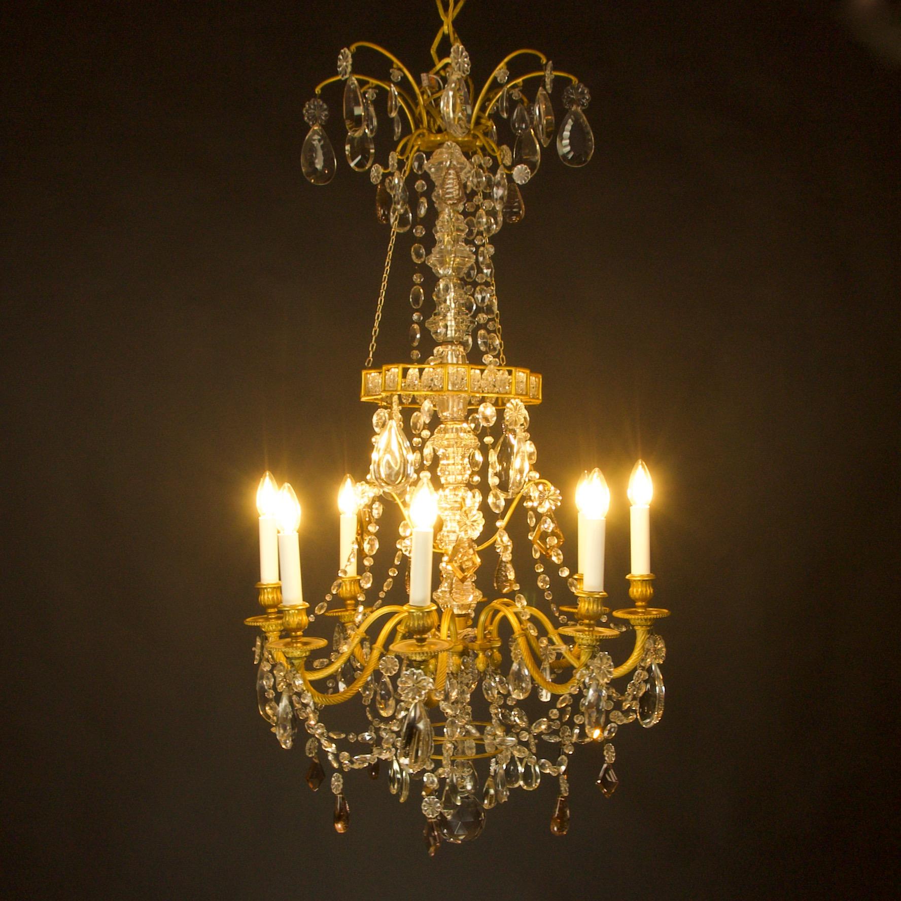 Late 19th century Louis XVI style eight light crystal cut and gilt-bronze chandelier attributed to Paris luxury lighting manufacterer Maison Baguès. 
This eight-light chandelier features an elegant and detailed bronze frame hang with heavy high