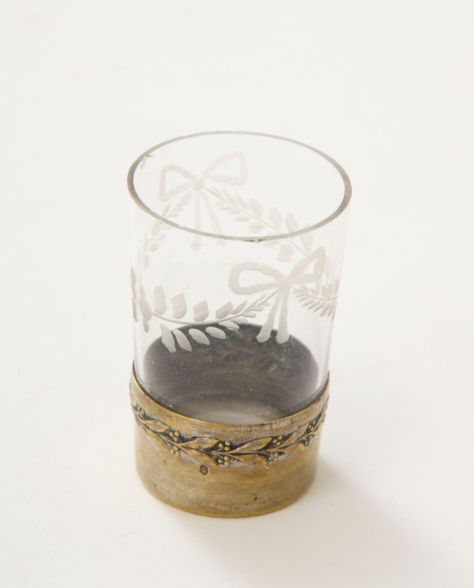 A classical French Etched Glass Liqueur set and glasses with bow and garland decoration and brass collar