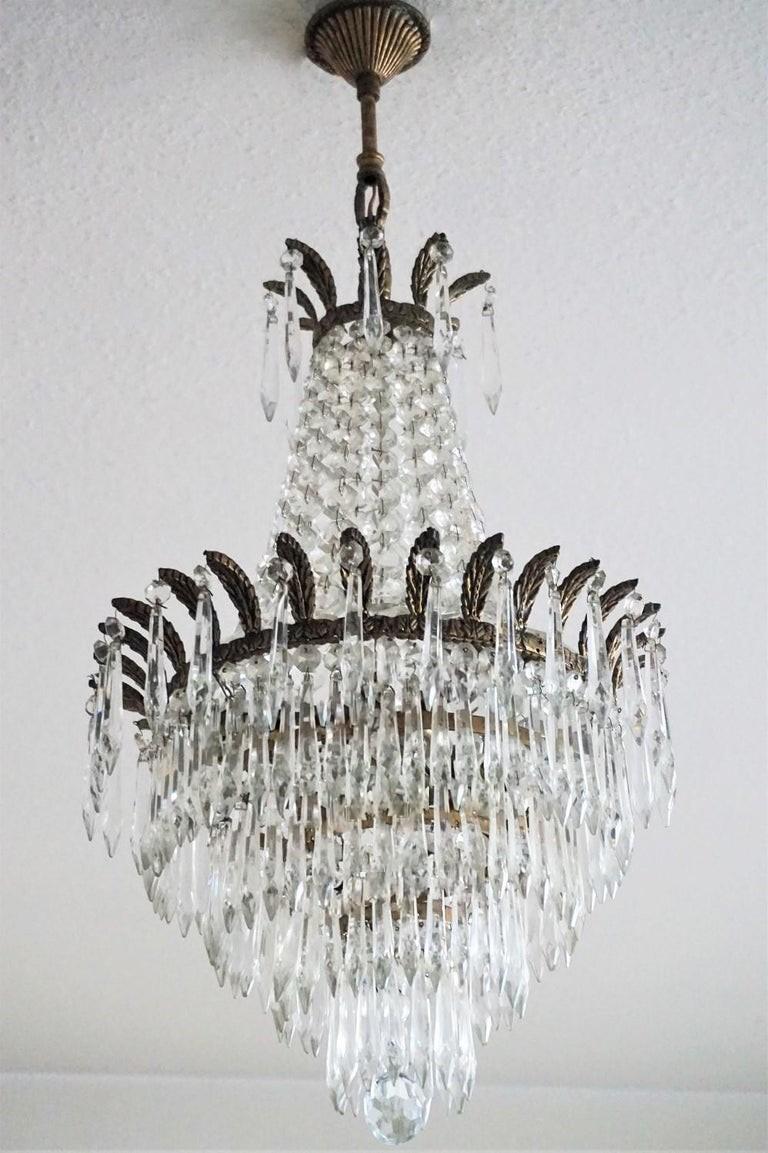 A lovely French crystal waterfall chandelier with five-tier icicle cut crystal, solid bronze crown shaped mounts, France, 1910-1920.
All crystals have been cleaned to its original shining.
Number of lights: Three E14 bulb sockets. Rewired and