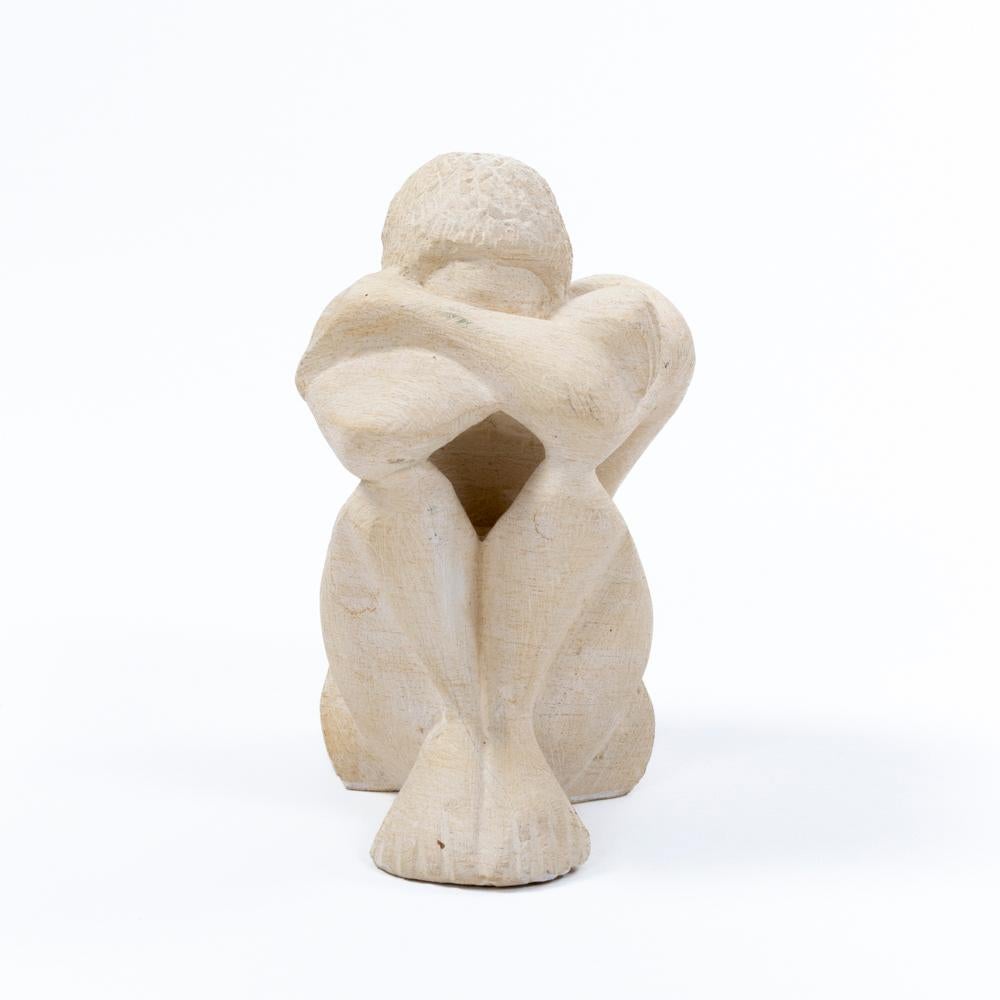 Französische Sandsteinskulptur aus der Zeit des Art déco.
Ein Mann sitzt mit angewinkelten Knien auf dem Boden, die Arme verschränkt und den Kopf eingezogen.
Die Körperhaltung lässt auf eine sehr kontemplative Person schließen.
Die Oberfläche der