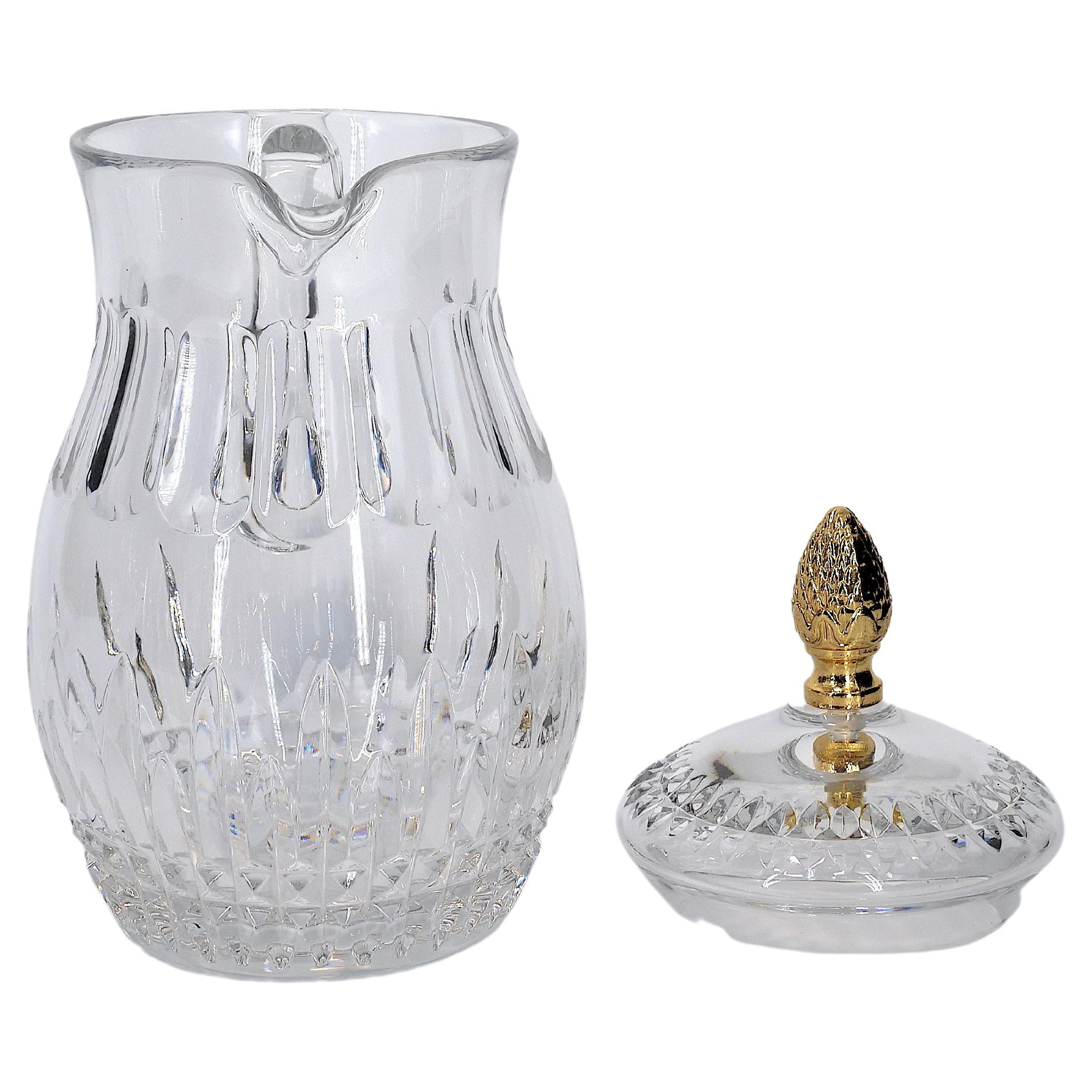 Late 20th century cut crystal tableware / barware covered serving pitcher. The piece features a gilt top brass pinecone finial covers with single side handle resting on a round shape base with exterior cut crystal design details. The pitcher is in