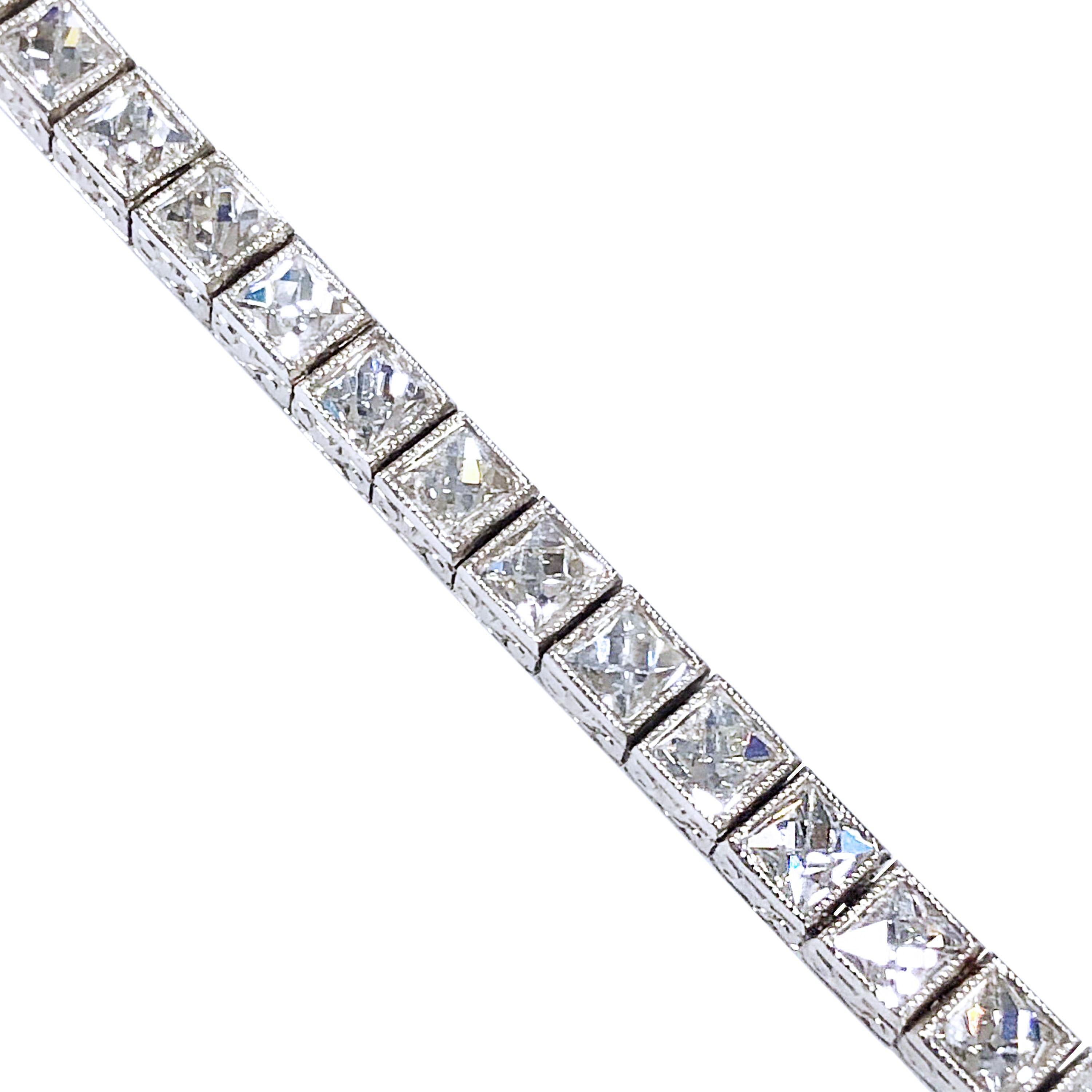An Art Deco style Platinum Line Bracelet of French Cut Diamonds, measuring 7 1/4 inches in length and 3/16 inch wide. Each box setting is articulated for soft flexibility, milgrain and hand engraved detail throughout. The French Cut Diamonds are all
