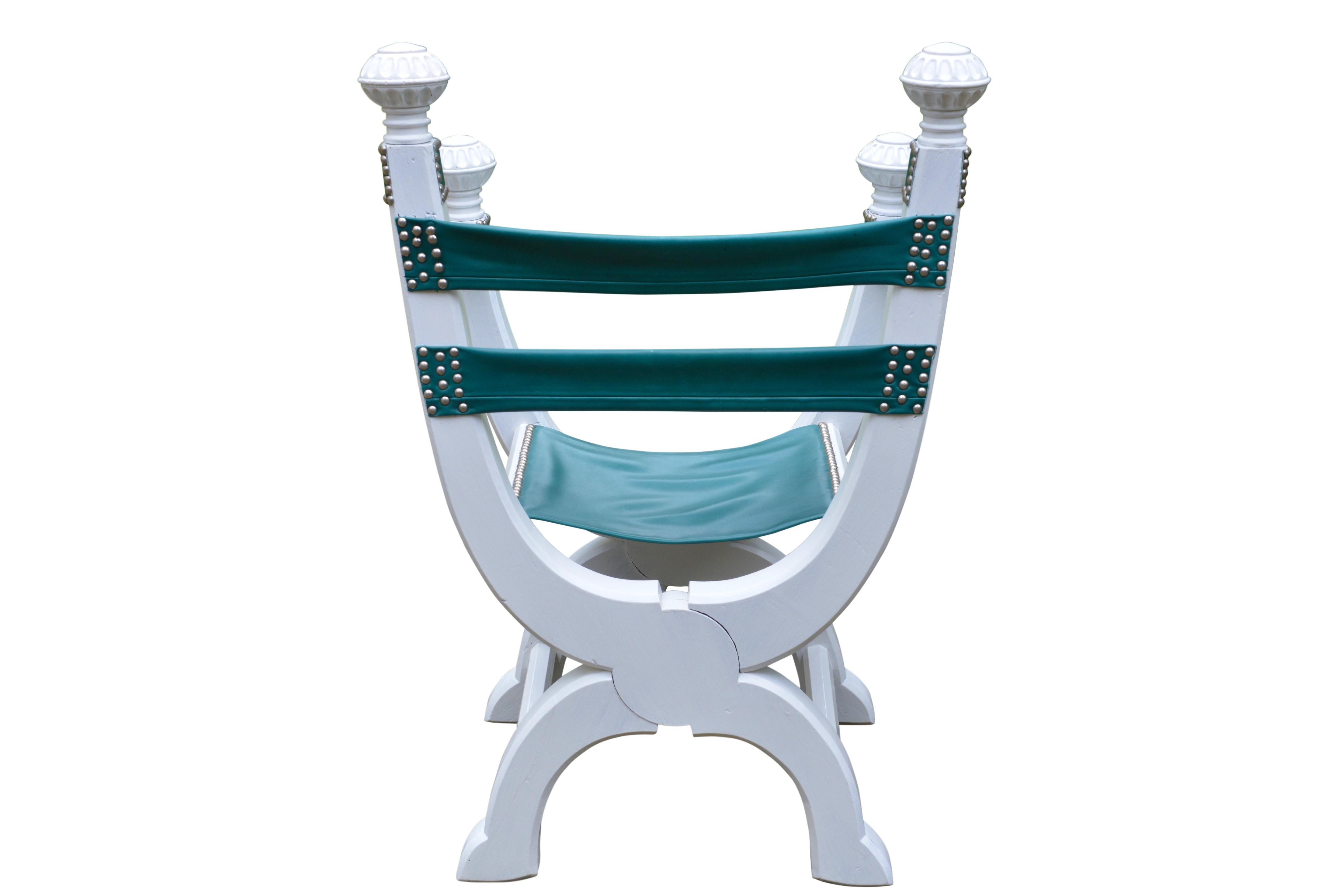 Funky white painted oak Dagobert type chair with aqua green colored leather seat and backrest. Finished with chrome studs. The Dagobert is an X shaped chair usually carved and upholstered in leather. Variations appeared in French, Italian, Spanish