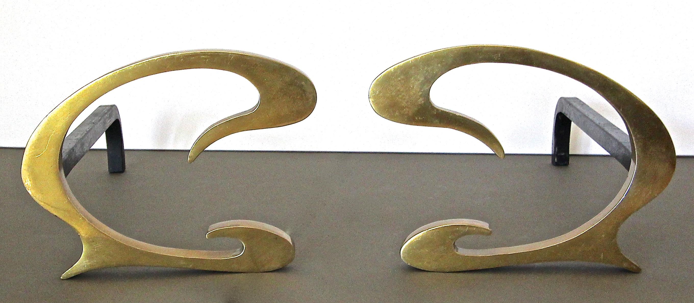 Pair of French Deco solid brass C-scroll shaped andirons. Heavy thick construction. Nice patina to brass. 