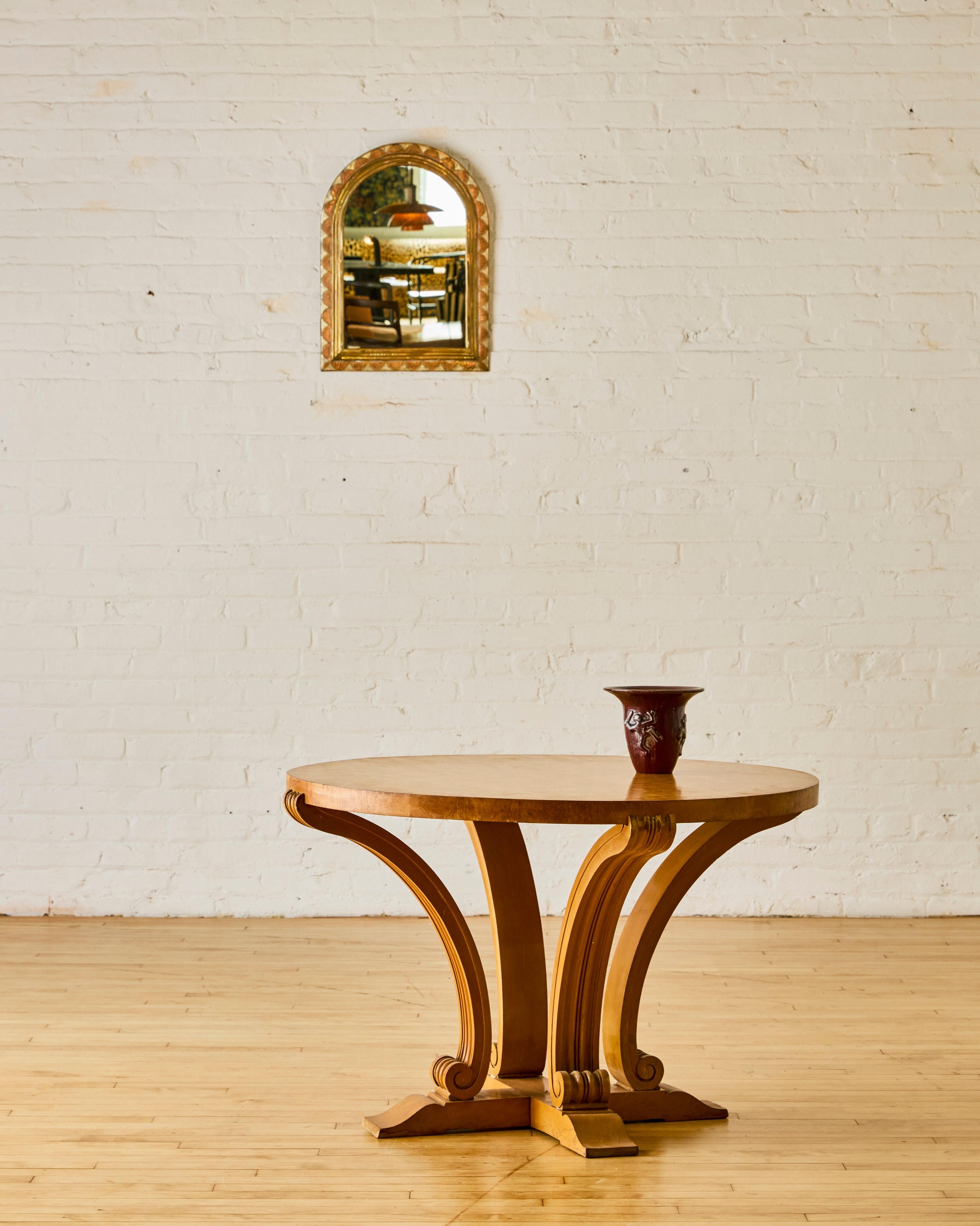 Table d'appoint basse et ronde de style art déco français C.I.C. 1935 avec quatre pieds en forme de volutes.