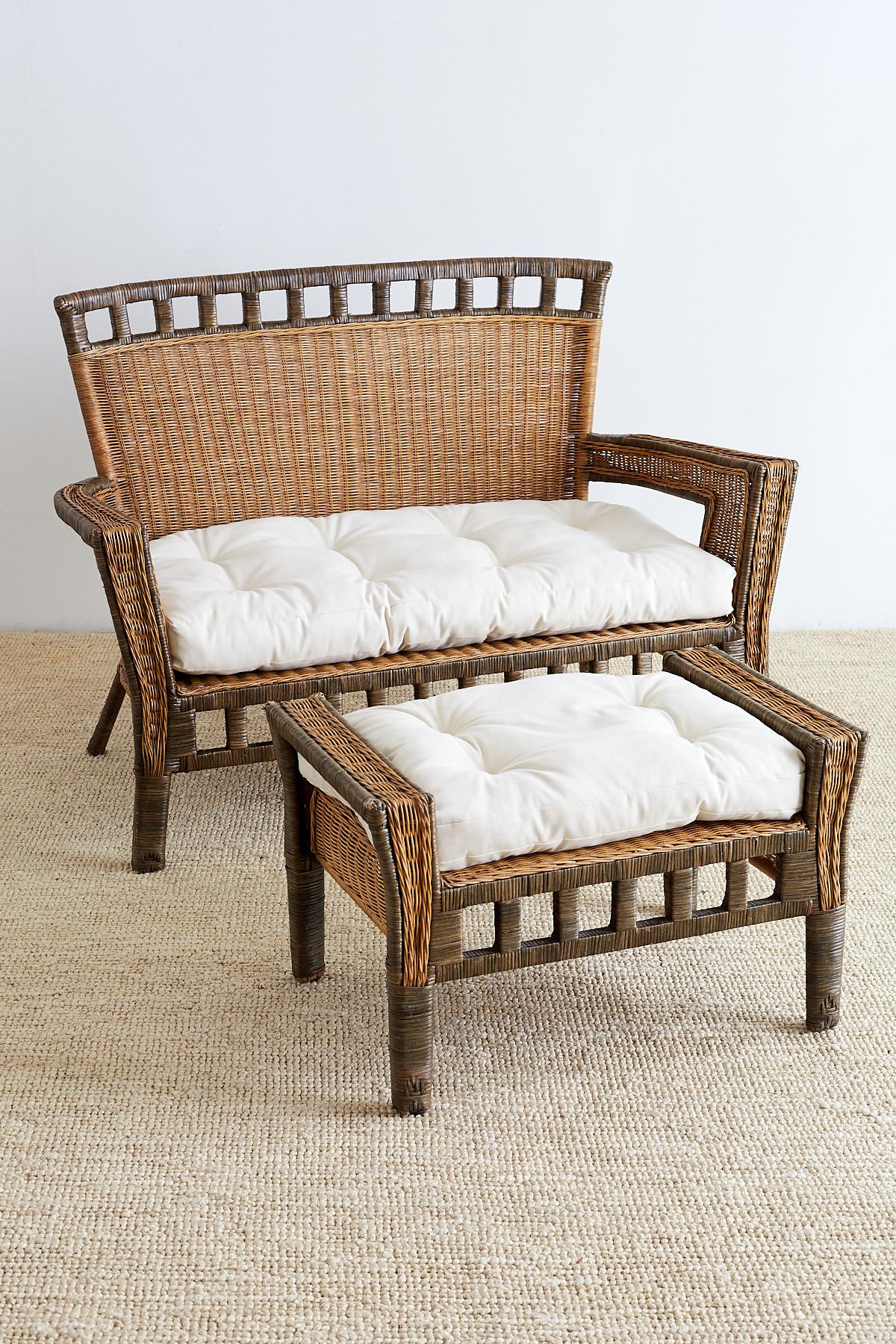 Handsome French Art Deco style rattan and wicker settee with ottoman. Features a square back rattan frame covered with wicker. The back and apron have a geometric square design and the frame has a contrasting green accent of rattan strapping. The