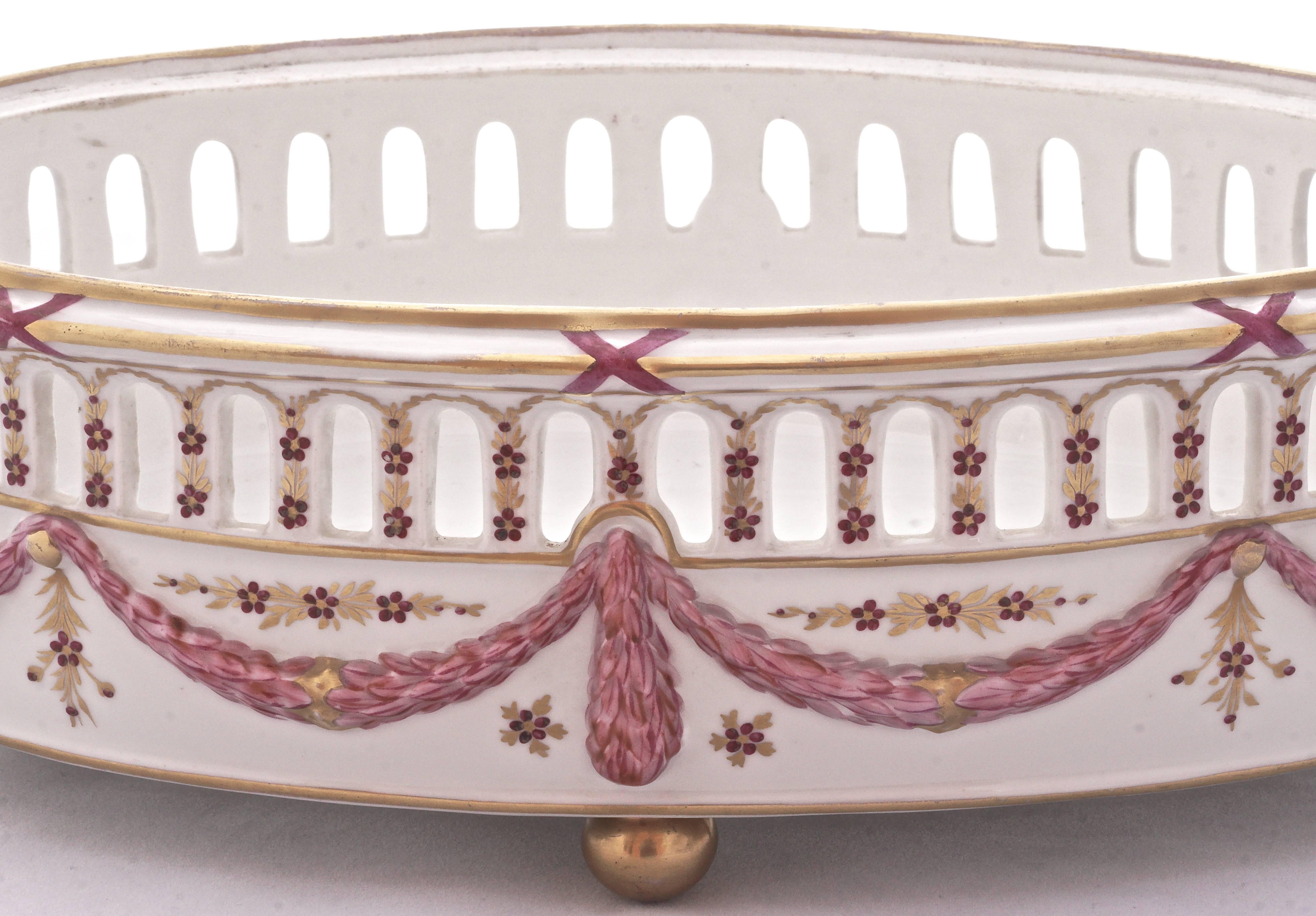 Beautiful oval vintage French porcelain basket standing on four golden ball feet. Featuring a floral hand painted design by Delvaux in shades of pink with gold highlights. Measuring 31cm, 12.2 inches, by 20.9cm, 8.2 inches, by 10cm, 3.9 inches. It