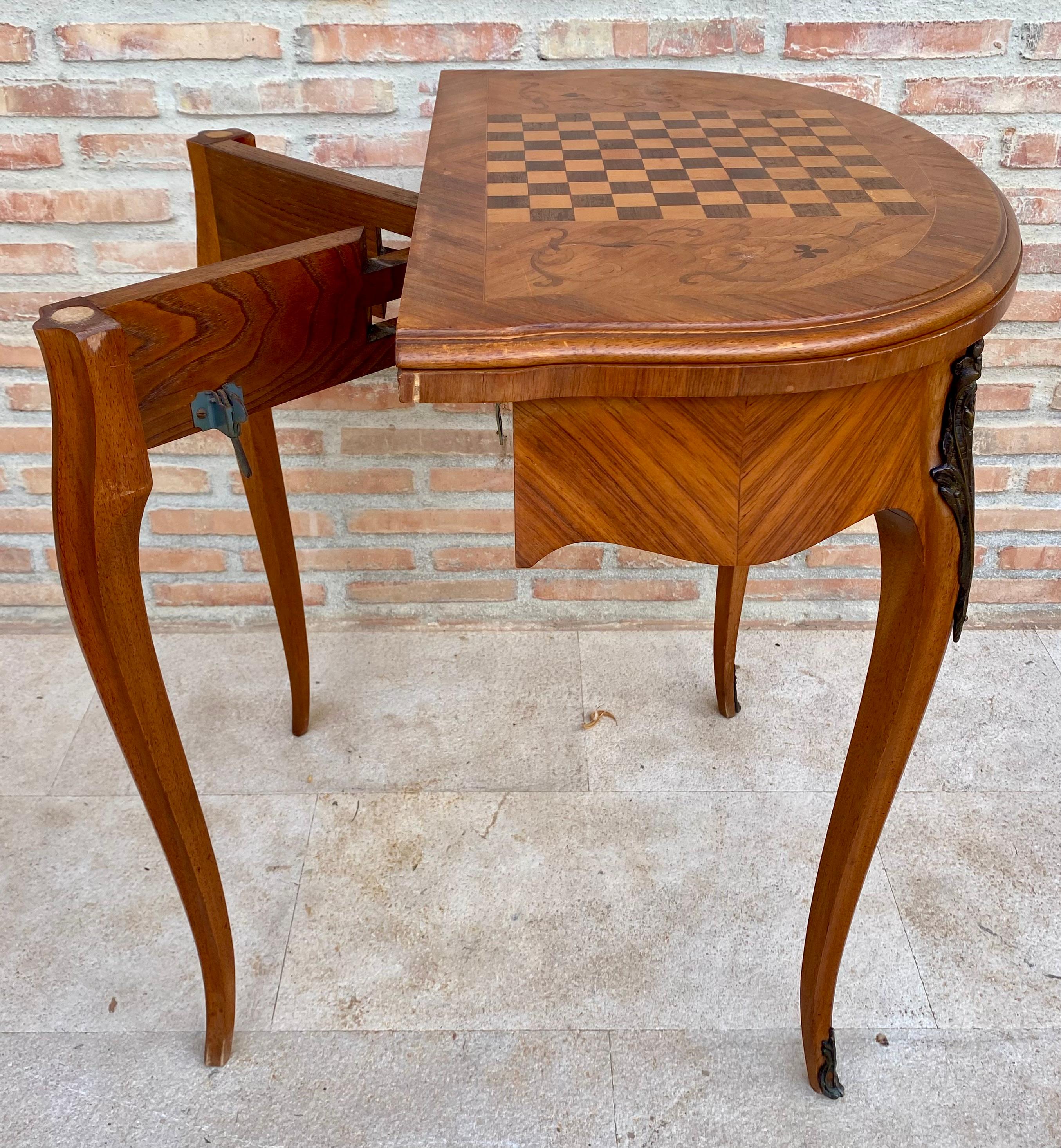 Beautiful chess table on the top and card games when opened, its half-moon shape made of flamed walnut veneer from around 1940-1950 with legs decorated with bronze ornamentation. A very attractive and well made piece, done in Regency style, however