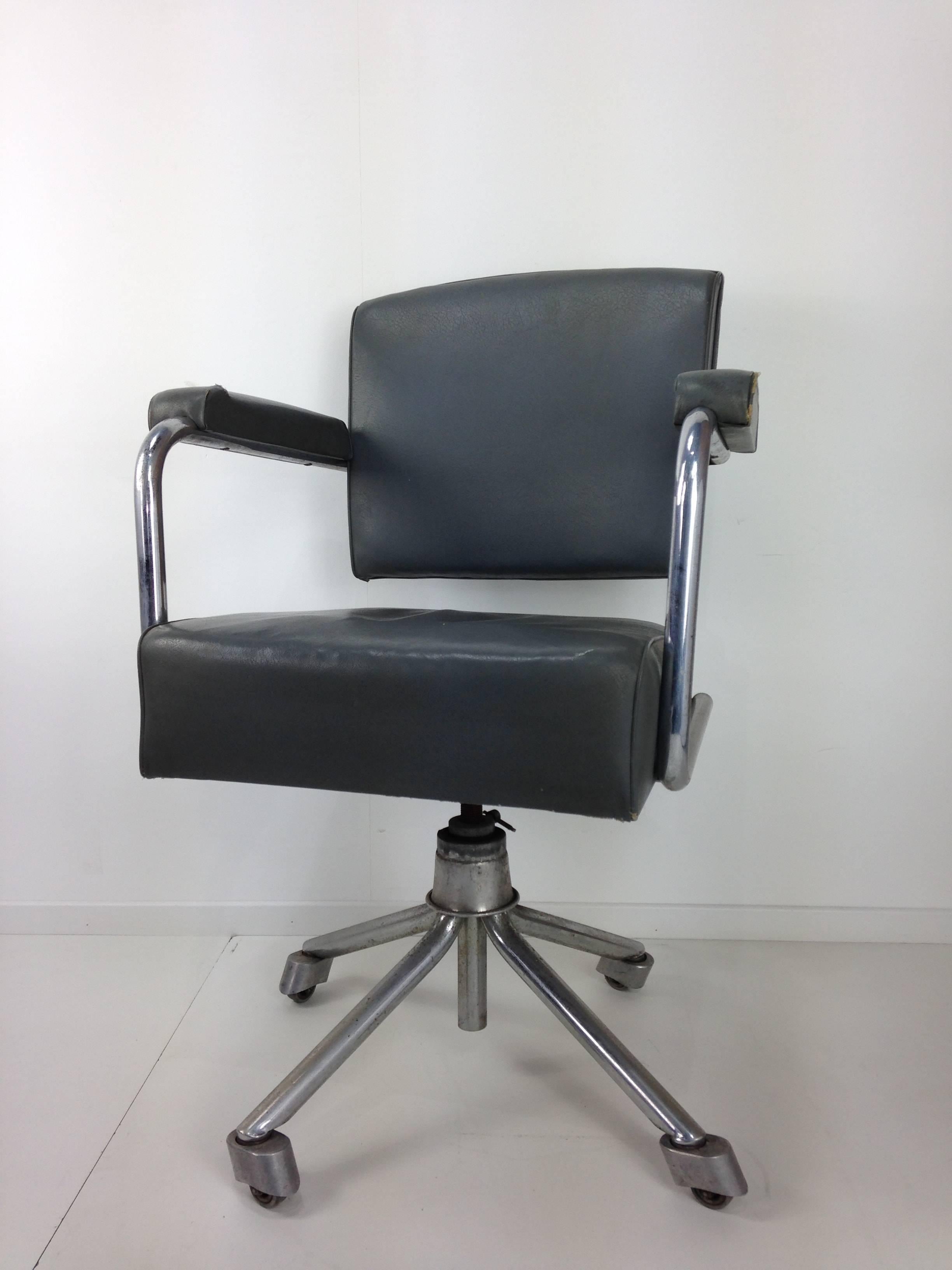 Straight out of a French factory that no longer exists today, this office chair with a Bauhaus look and resolutely industrial style, has a curved tubular metal structure, backrest and seat in gray leatherette, star base to rotate and adjust in