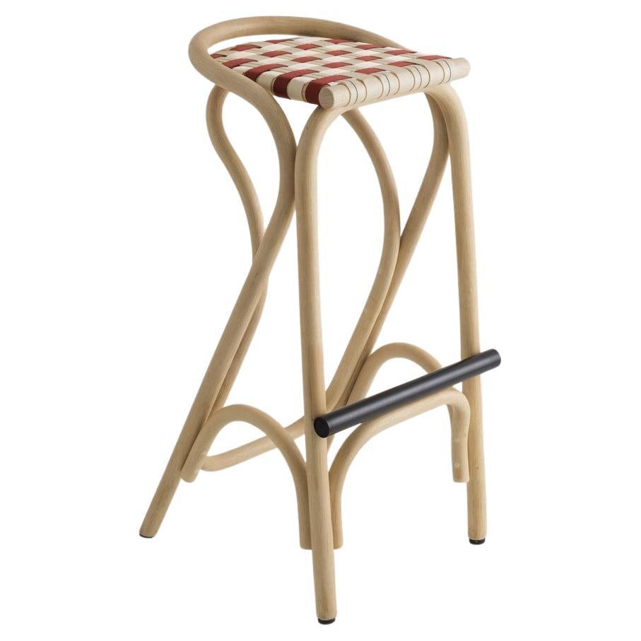 Combining modernity and tradition, design, graphic lines and timelessness this stool is composed of a robust rattan and airy structure, a black metal footrest and handbraided fabric canva stripes seat.