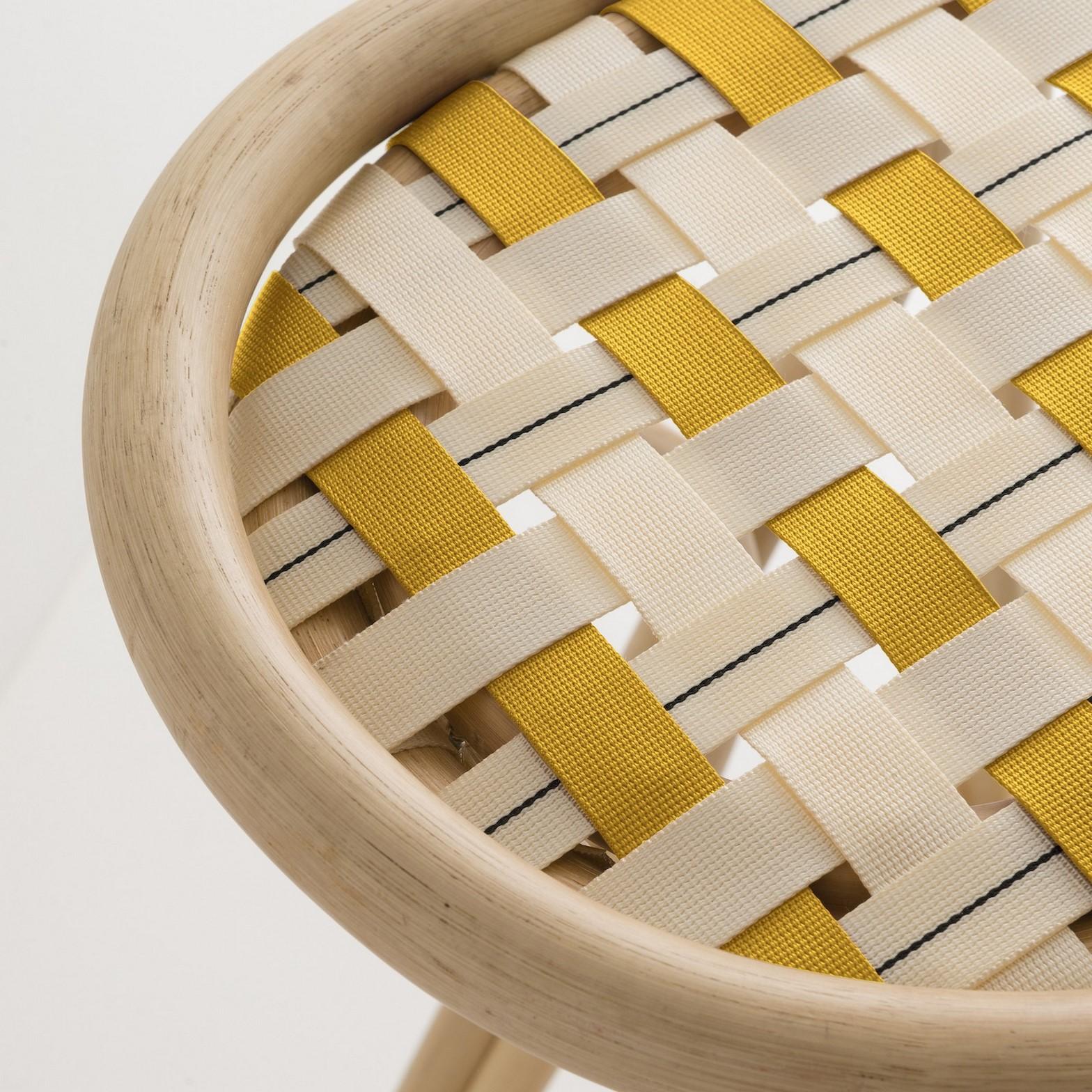 Combining modernity and tradition, design, graphic lines and timelessness this stool is composed of a robust rattan and airy structure, a black metal footrest and handbraided fabric canva stripes seat.