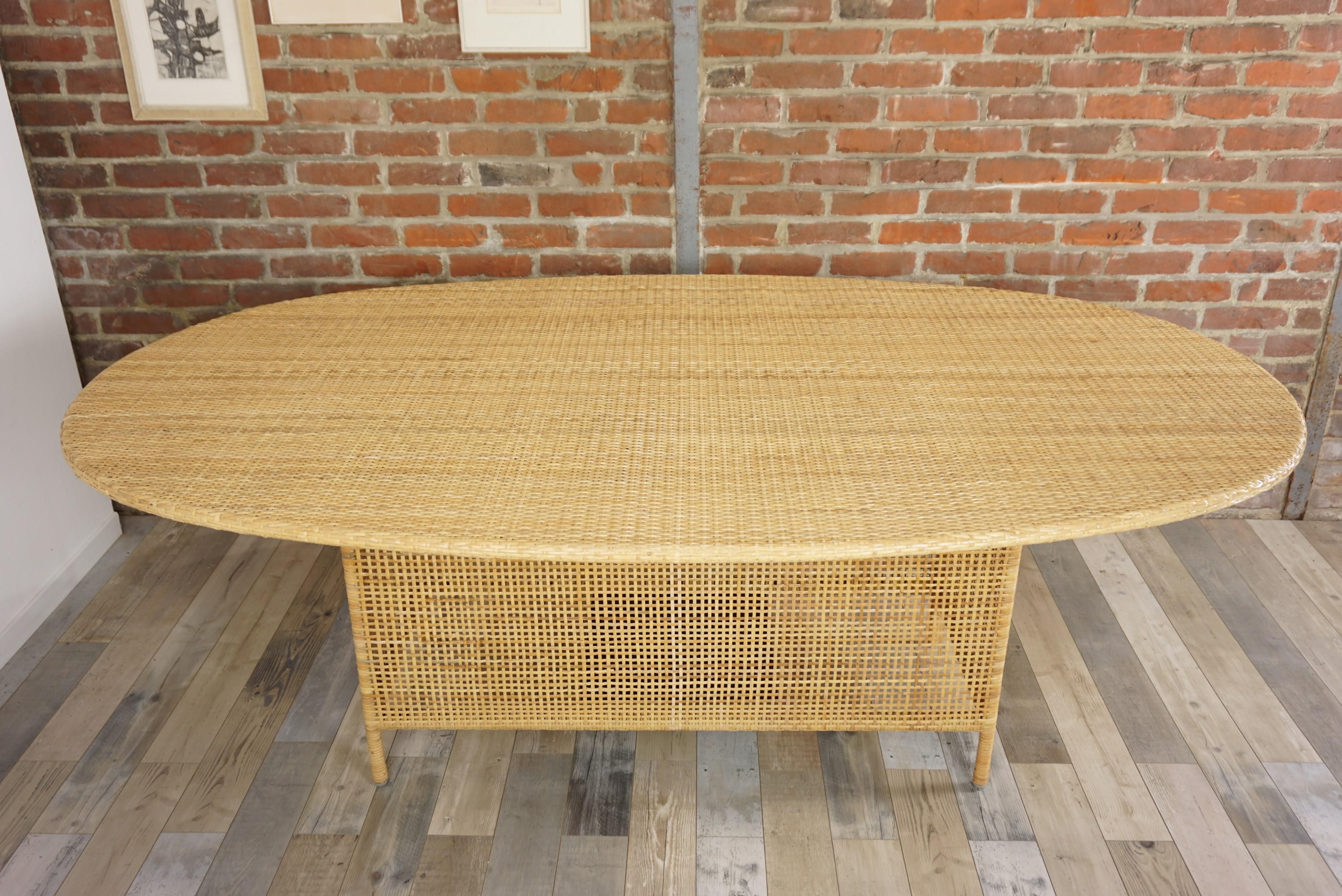French design and oval dining table composed of a metal structure adorned with hand braided rattan. Elegance and transparency, aerial and Hollywood Regency style, in excellent state. (Never used).