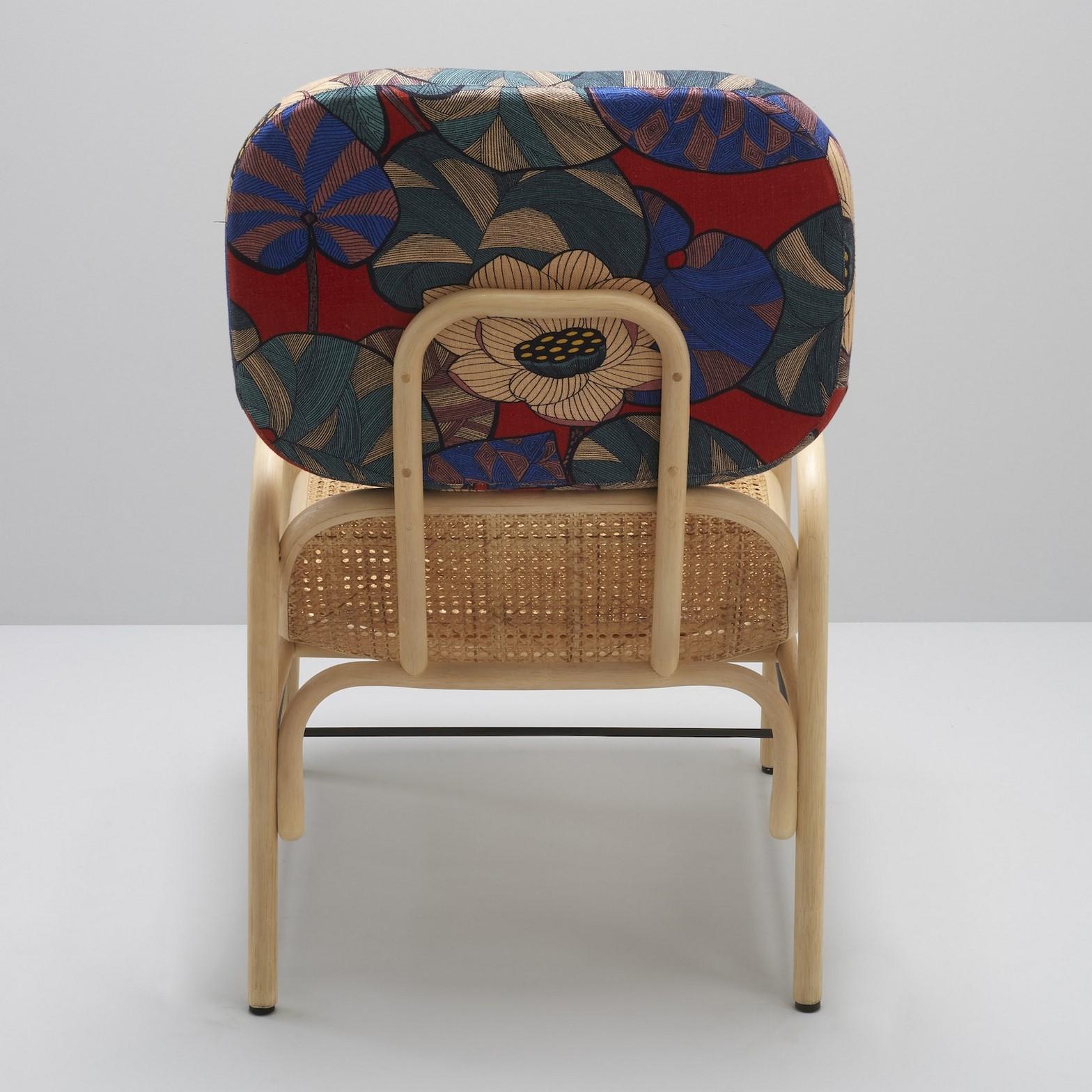 Combining modernity and tradition, design, graphic lines and timelessness this lounger chair is composed of a robust curved rattan and airy structure, a cane seat and a soft fabric adorning the comfy headrest.