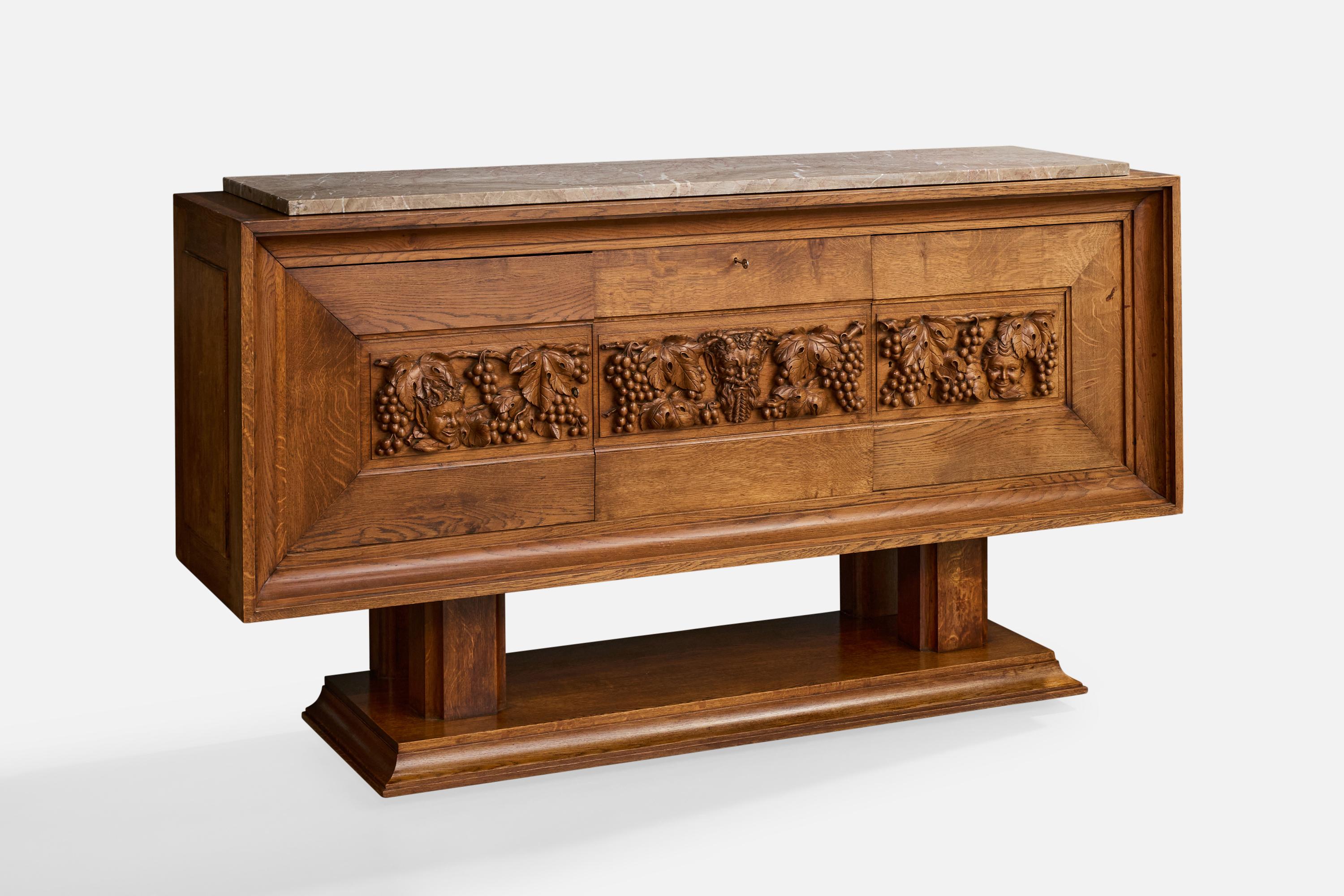 Un mobile o credenza in Oak e marmo con rilievi decorativi intagliati, progettato e prodotto in Francia, negli anni '40 circa.

Dimensioni complessive (pollici): 37,4 