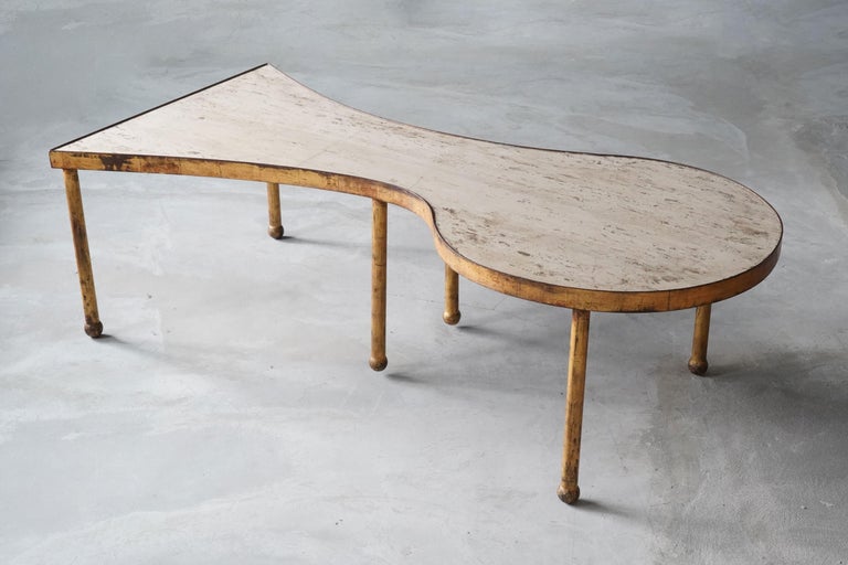 A freeform coffee table / cocktail table. Designed and produced in France, 1950s. Features gilt steel, and it's original travertine top.

Other designers of the period include Jean Royère, Gio Ponti, Paolo Buffa, T.H. Robsjohn-Gibbings, and Isamu