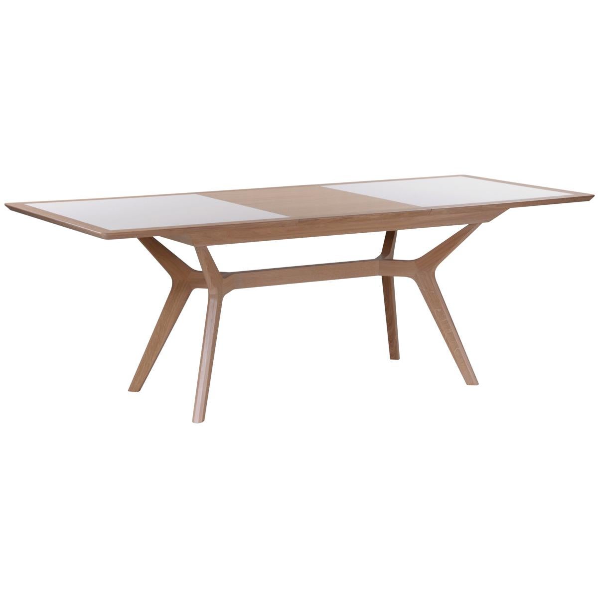 This extensible dining table is proposed in solid oak wood for the feet and structure.
Table top is a 3mm white ceramic plate. One single wooden leaf extension of 60 cm / 23.0’’ is integrated and folded under the table top.
This extension is made of