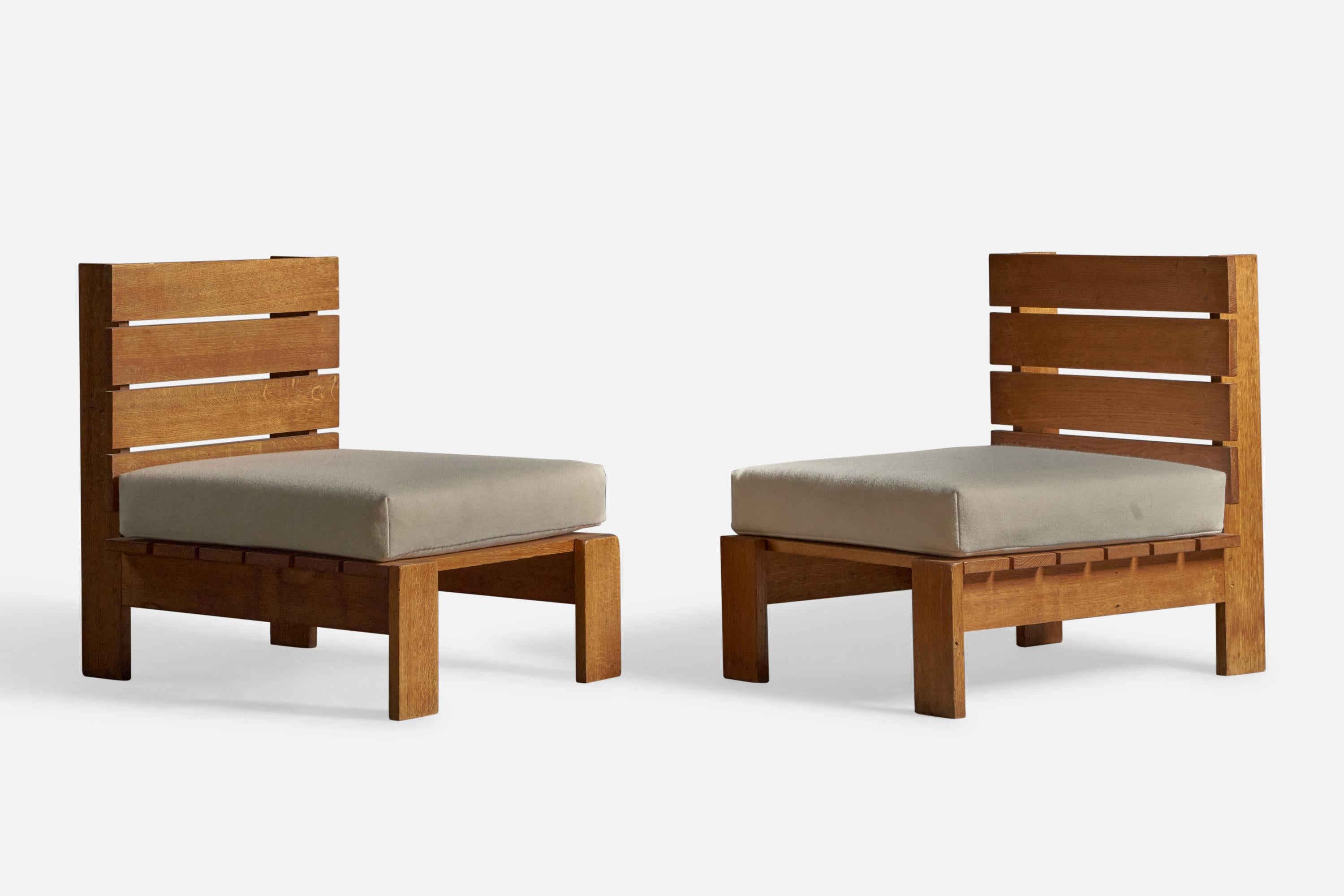 A pair of solid oak and beige fabric lounge chairs or slipper chairs, designed and produced in France, c. 1970s.
