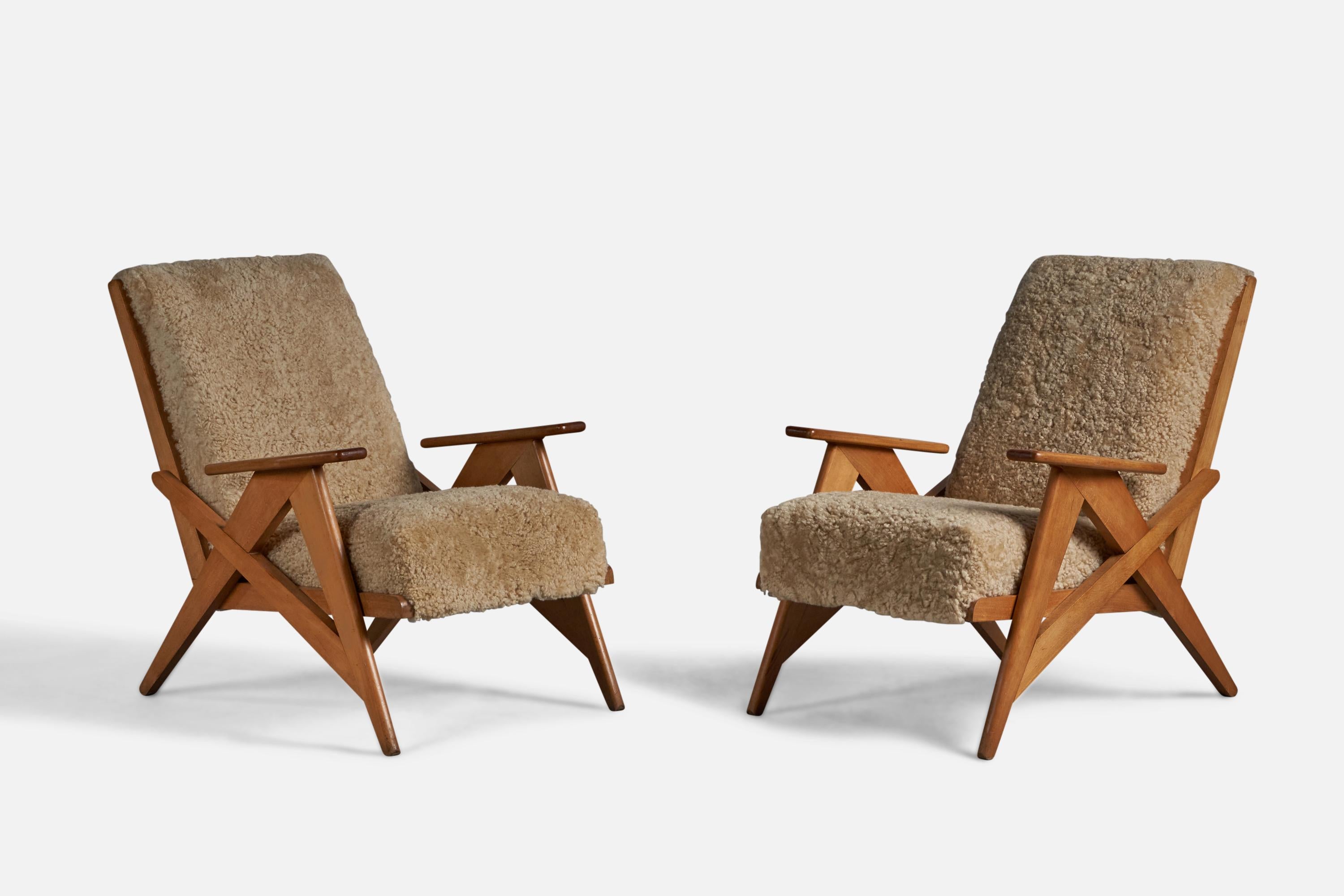 A pair of solid oak and beige shearling lounge chairs designed and produced in France, 1950s.

17.5