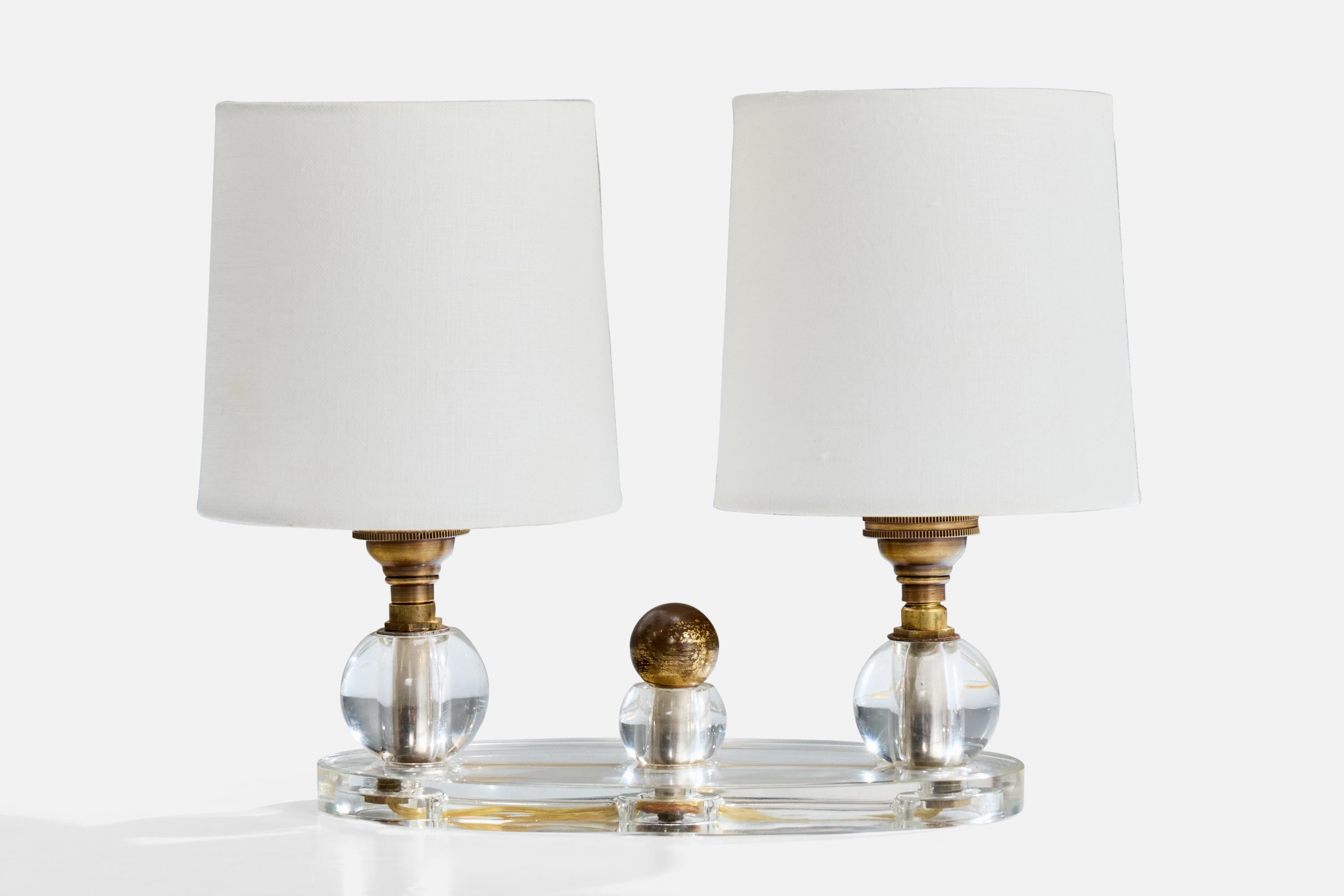 Lampe de table en laiton, verre et tissu blanc, conçue et produite en France, C.C. 1940.

Présence d'oxydation sur le laiton. 

Remplacement des douilles et abat-jour neufs.

Usure correspondant à l'âge et à l'usage.

Dimensions globales (pouces) :