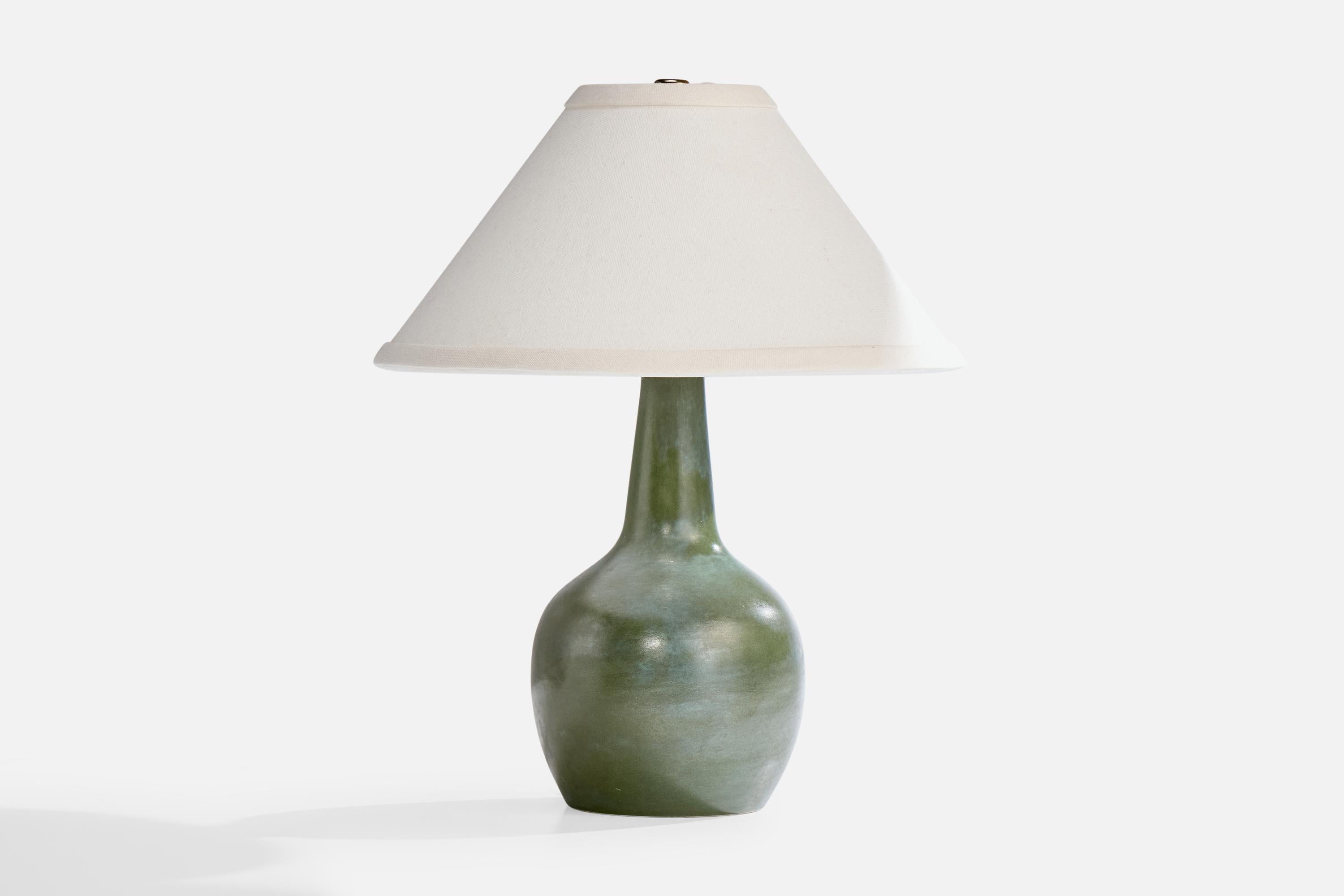 A blue green-glazed ceramic table lamp designed and produced in France, c. 1950s.

Wear consistent with age and use

Dimensions of Shade (inches): 3” Top Diameter x 10.25” Bottom Diameter x 5.5” Height

Dimensions of Lamp with Shade (inches): 12.75”