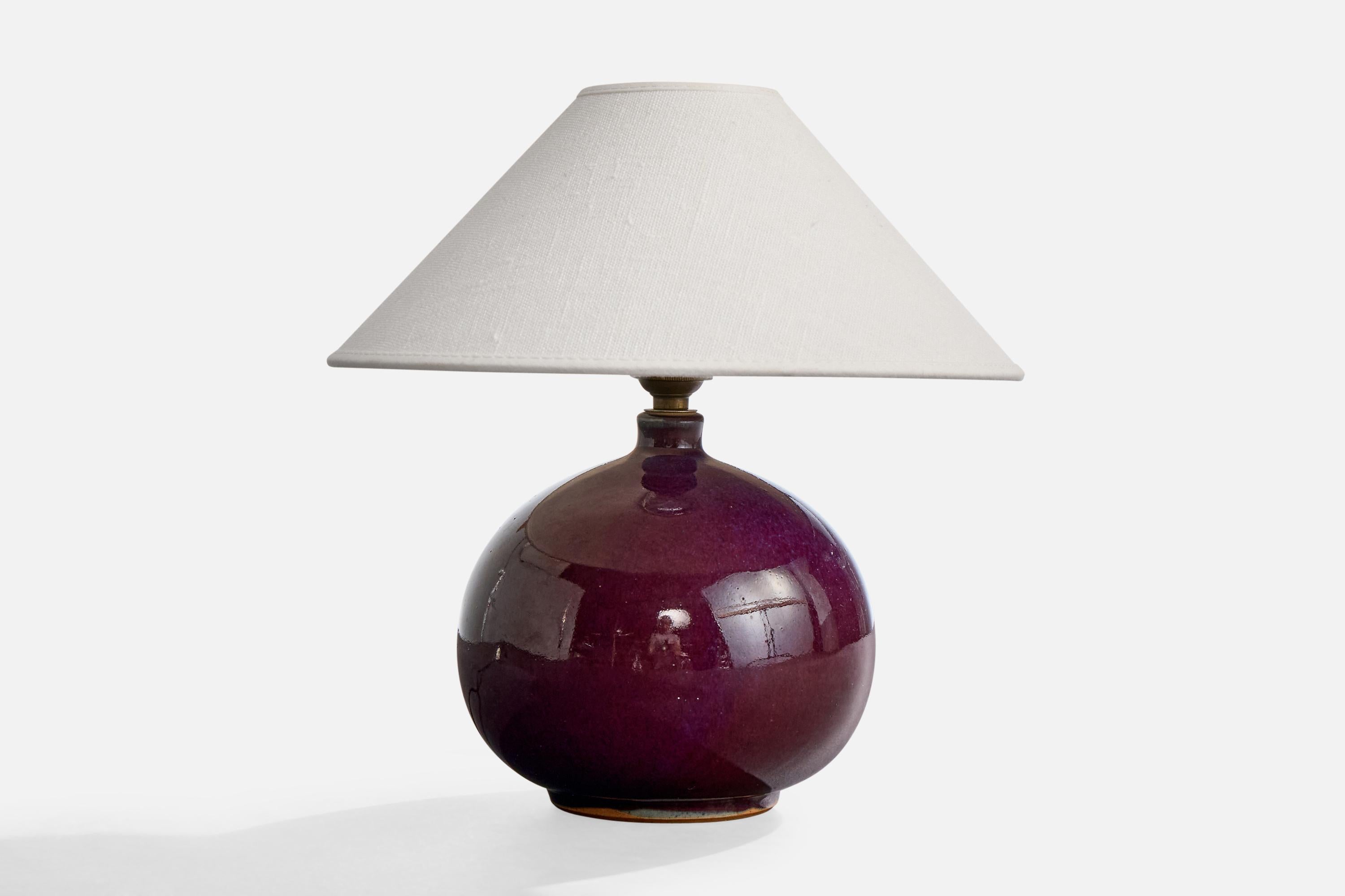A purple-glazed ceramic table lamp designed and produced in France, c. 1950s.

Wear consistent with age and use

Dimensions of Shade (inches): 3” Top Diameter x 10” Bottom Diameter x 4” Height

Dimensions of Lamp with Shade (inches): 10.5” Height x