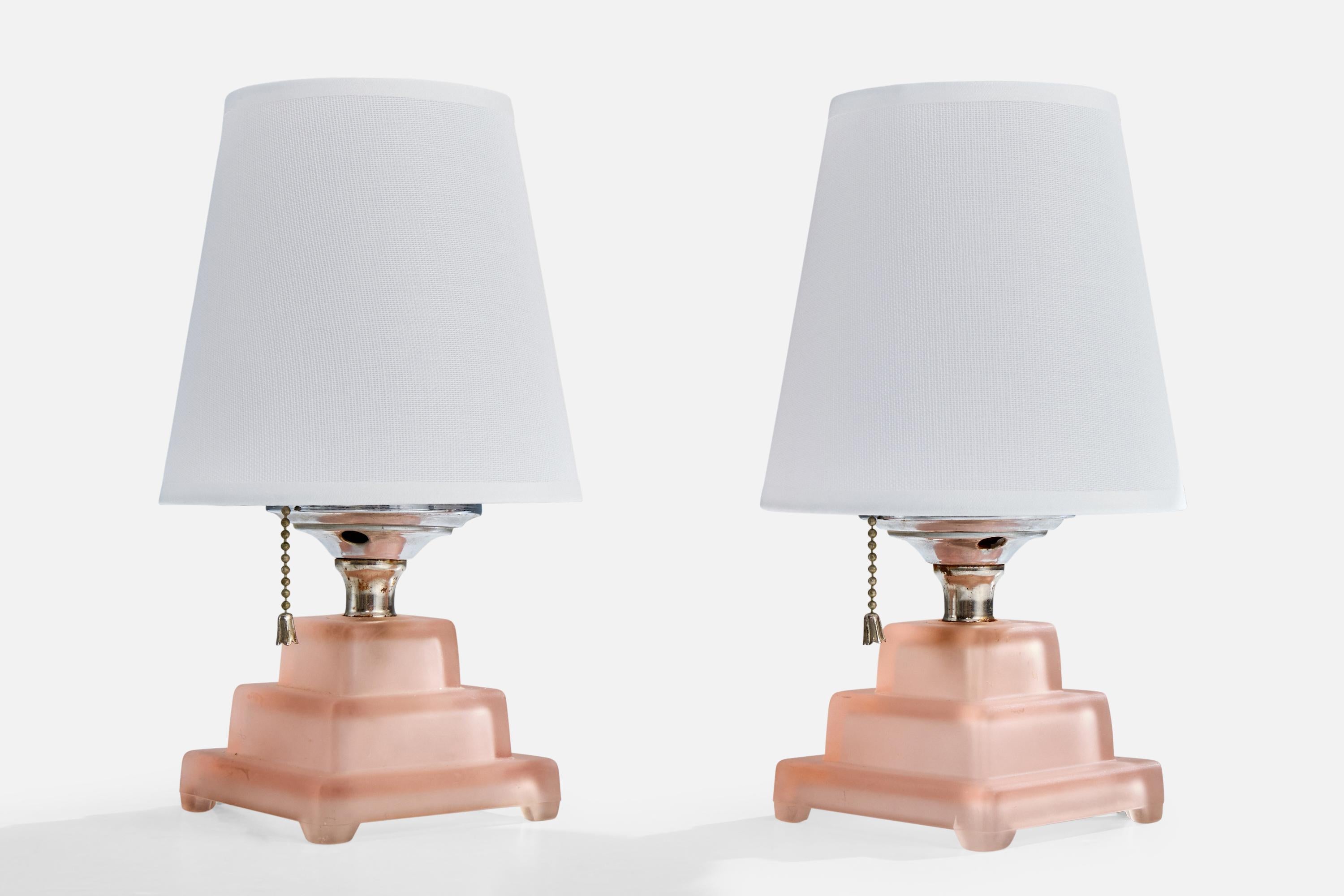 A pair of pink glass, chrome-plated metal and white fabric table lamps designed and produced in France, c. 1950s.

Oxidation present to metal

Wear consistent with age and use

Overall Dimensions (inches): 10.0