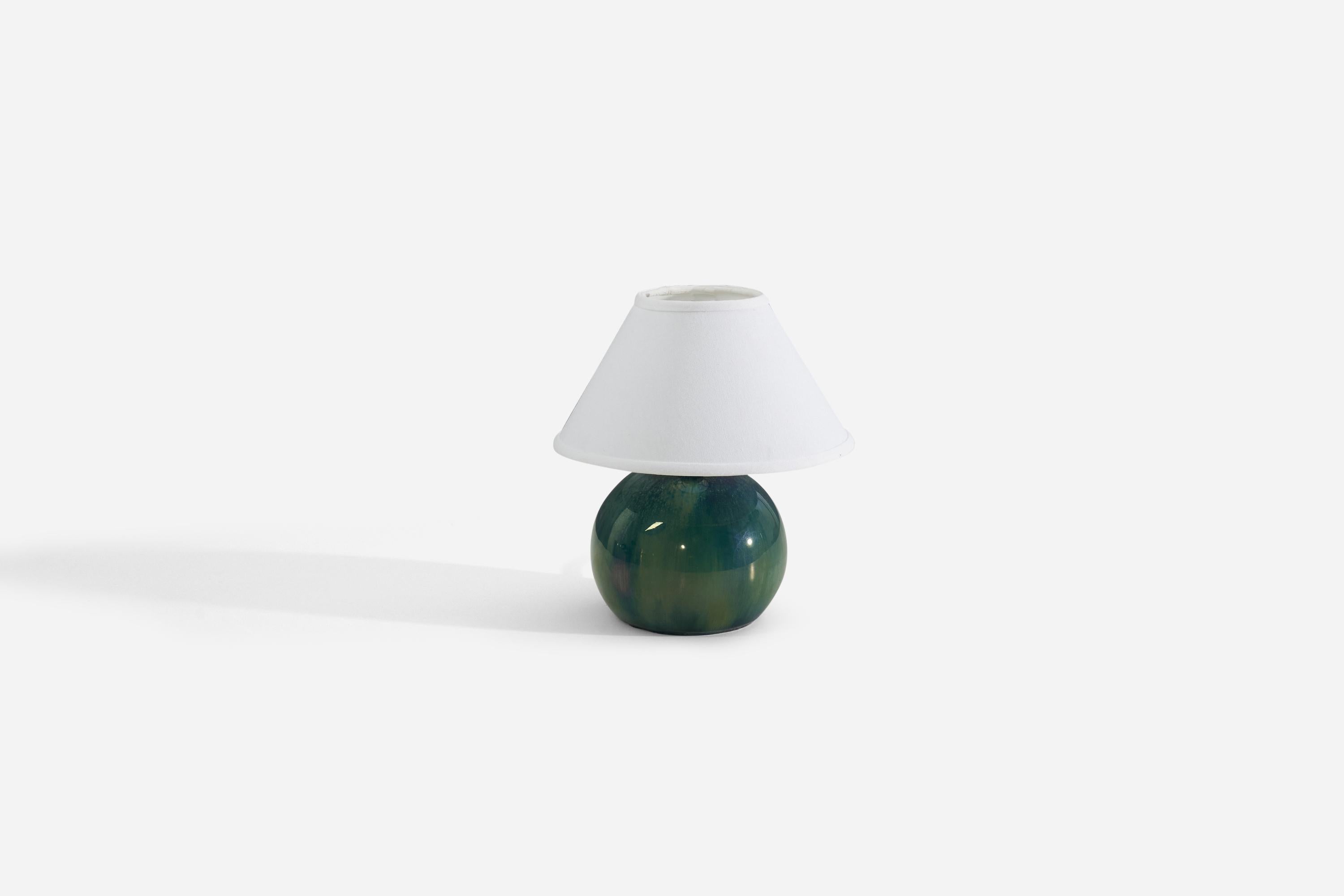 A green-glazed ceramic table lamp designed and produced in France, c. 1940s.

Measurements listed are of lamp, sold without lampshade.

For reference:

Shade : 4.5 x 10.25 x 6
Lamp with shade : 11 x 10.25 x 10.25.
