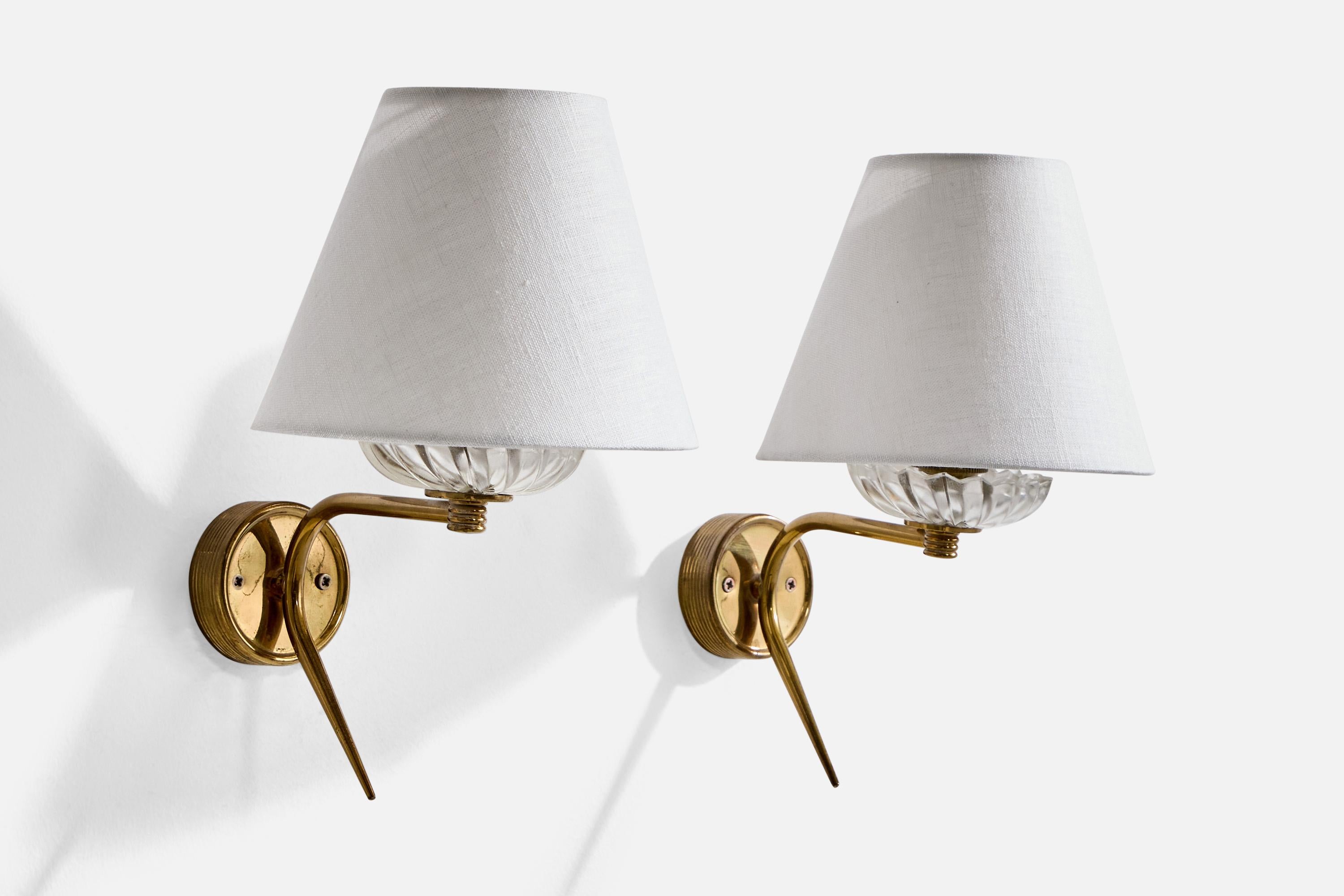 A pair of brass, glass and white fabric wall lights designed and produced in France, c. 1950s.

Overall Dimensions (inches): 10” H x 6.25” W x 8.25” D

Back Plate Dimensions (Inches): 2.5” H x 2.5” W x .85” D

Bulb Specifications: Bayonet

Number of