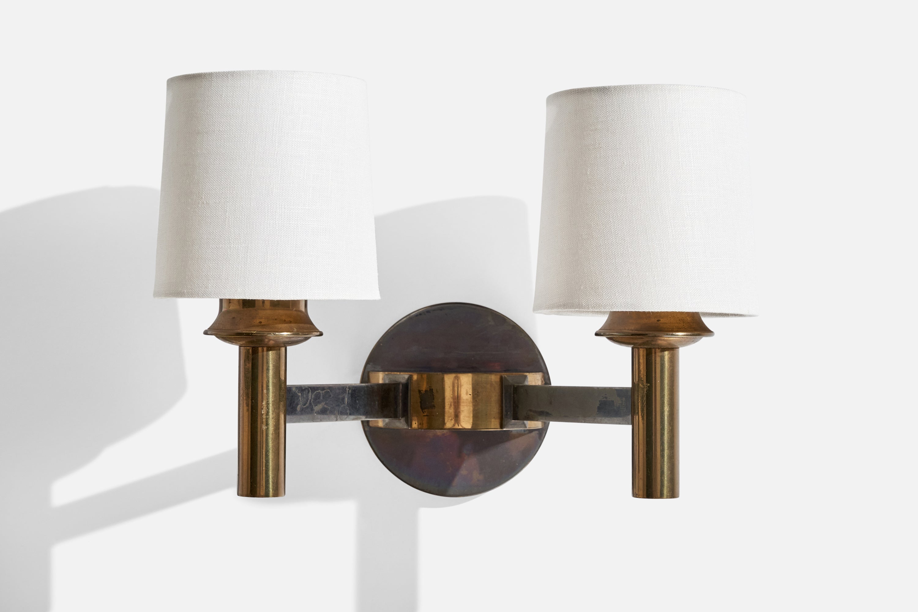 A brass, metal and white fabric wall light designed and produced in France, c. 1950s.

Overall Dimensions (inches):  8.125” H x  12.375” W x 7.5 “D
Back Plate Dimensions (Inches):  4.5” H x 4.5” W x 2” D
Bulb Specifications: E-14 Bulbs
Number of