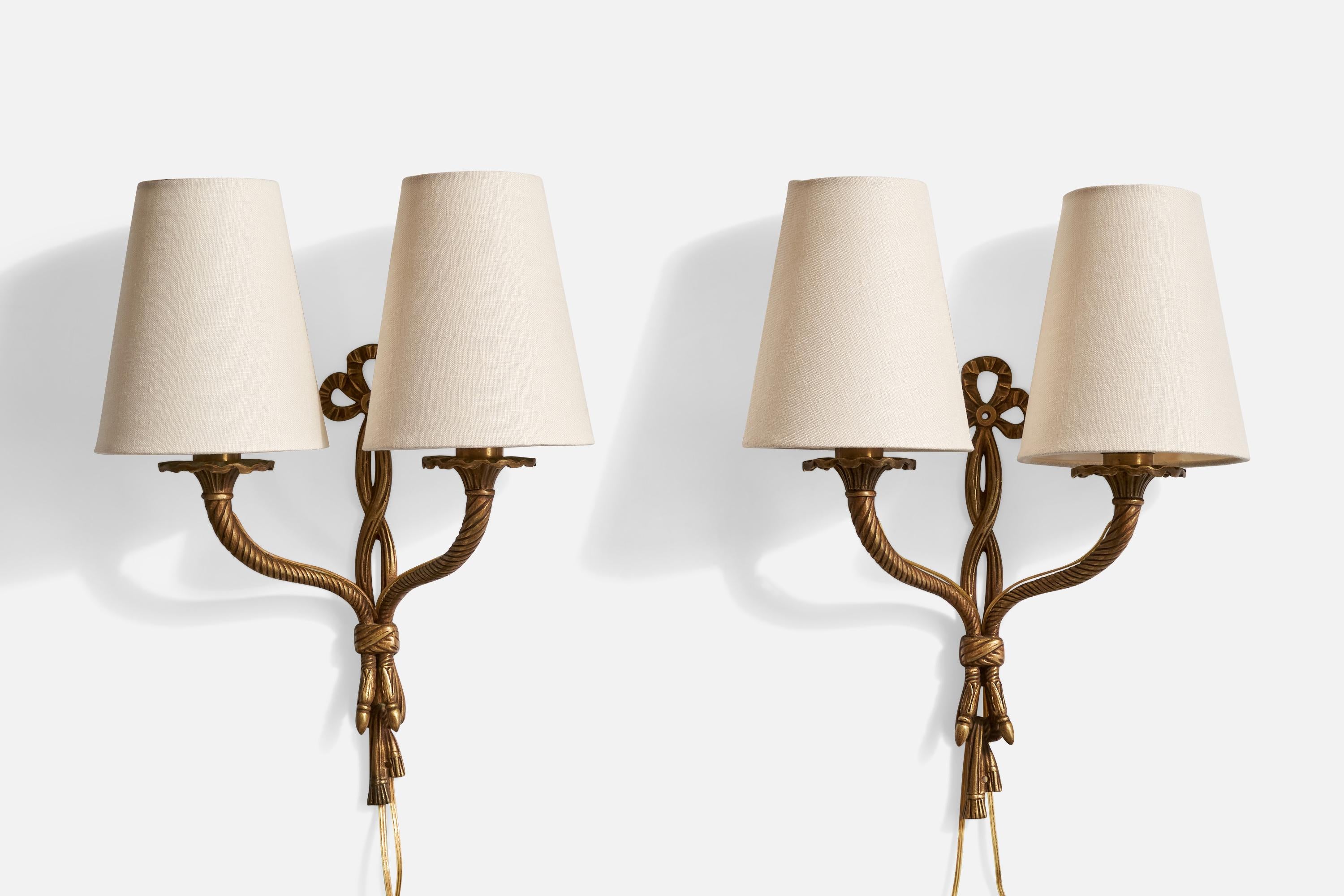 A pair of brass and white fabric wall lights designed and produced in France, c. 1940s.

Overall Dimensions (Inches): 14.4” H x 11.5” W x 5.5” D

Back Plate Dimensions (Inches): 10.75” H x 1.125” W x .25” D

Bulb Specifications: E-12

Number of