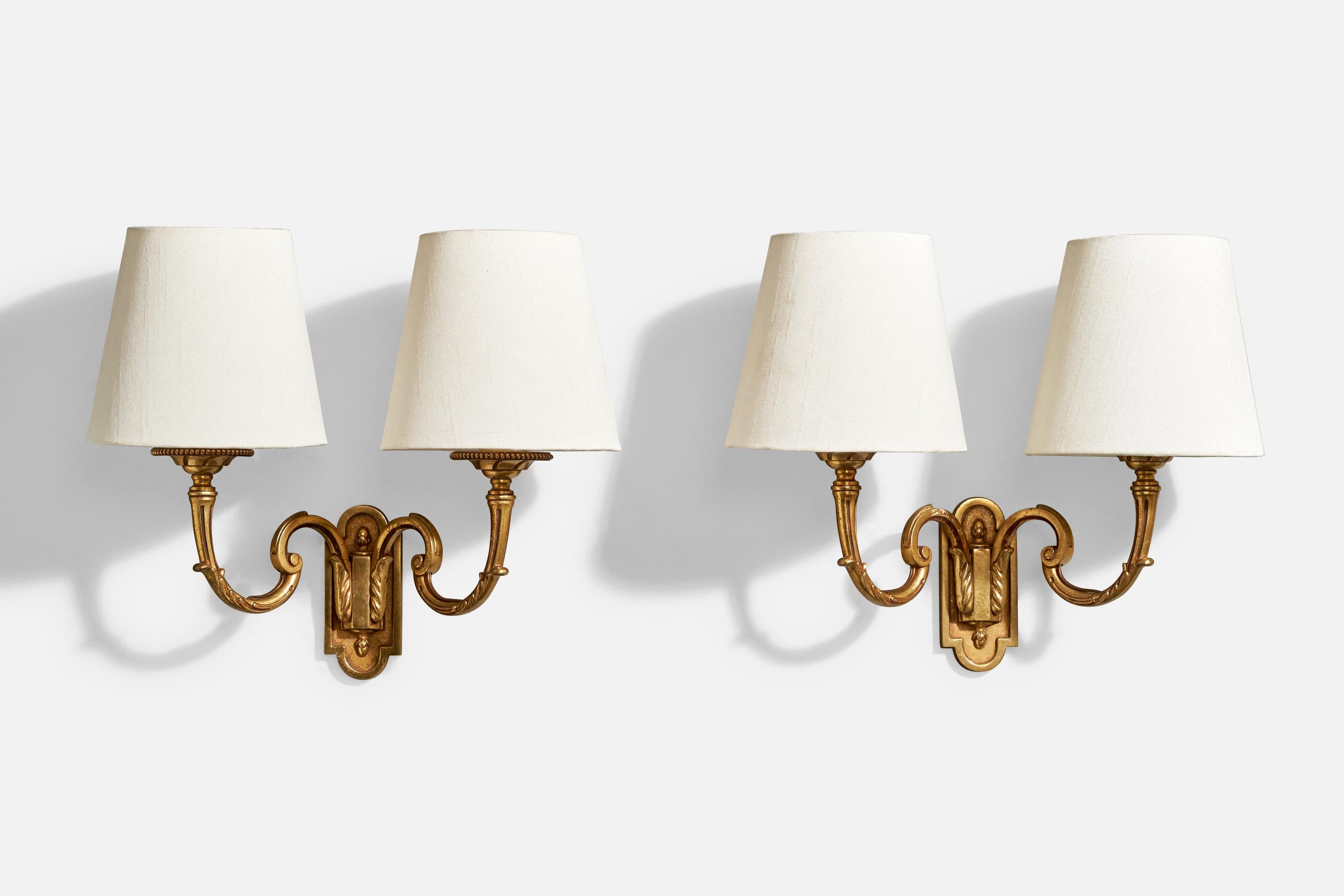 A pair of brass and white fabric wall lights designed and produced in France, c. 1950s.

Overall Dimensions (Inches): 12.6” H x 13.6” W x 6.7“ D

Back Plate Dimensions (Inches): 4.75” H x 2.125” W x .3” D

Bulb Specifications: E-14 incandescent