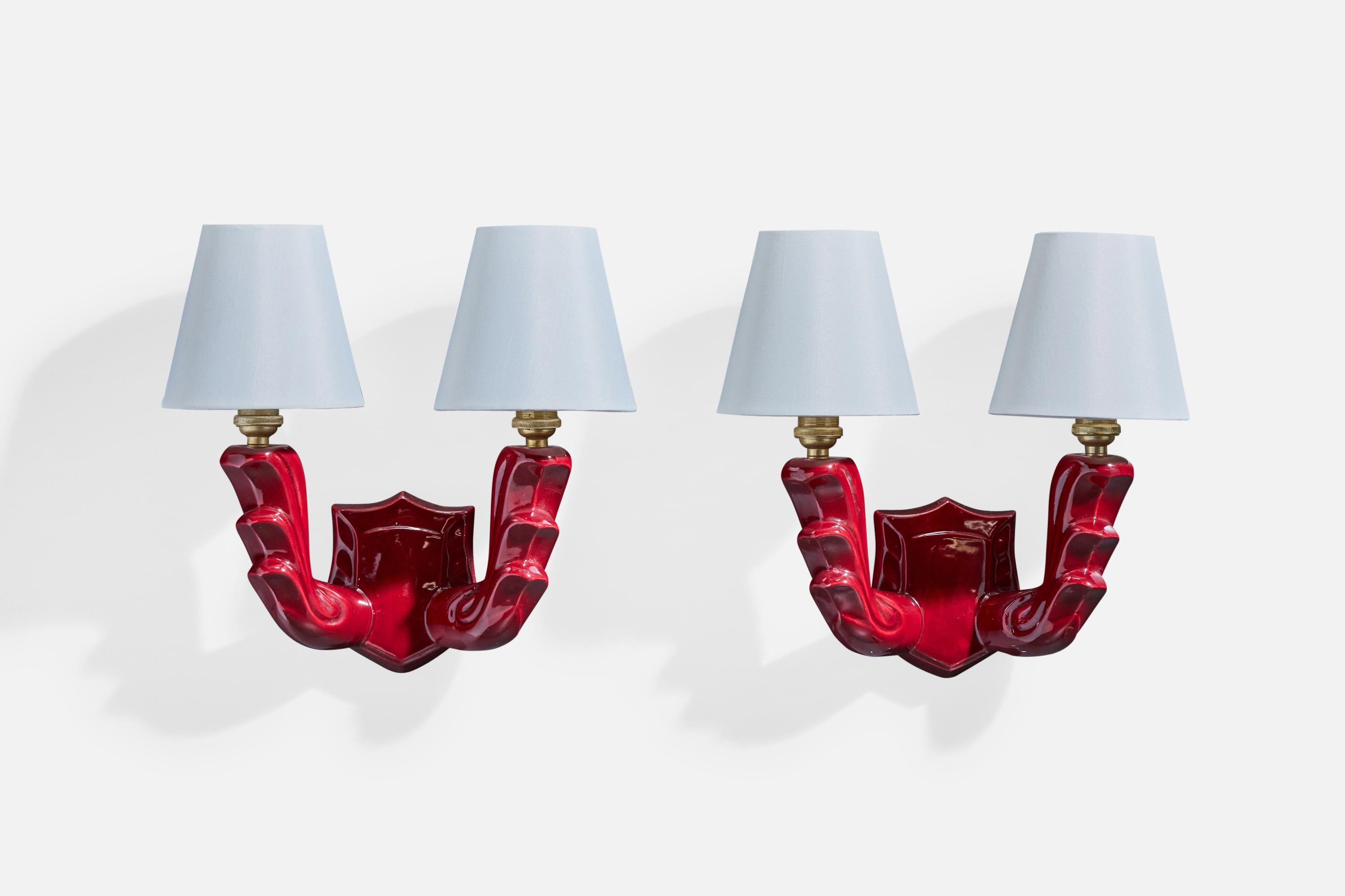 Coppia di applique in ceramica smaltata di rosso, ottone e tessuto bianco progettate e prodotte in Francia, anni '60 circa.

Dimensioni complessive (pollici): 11,5 