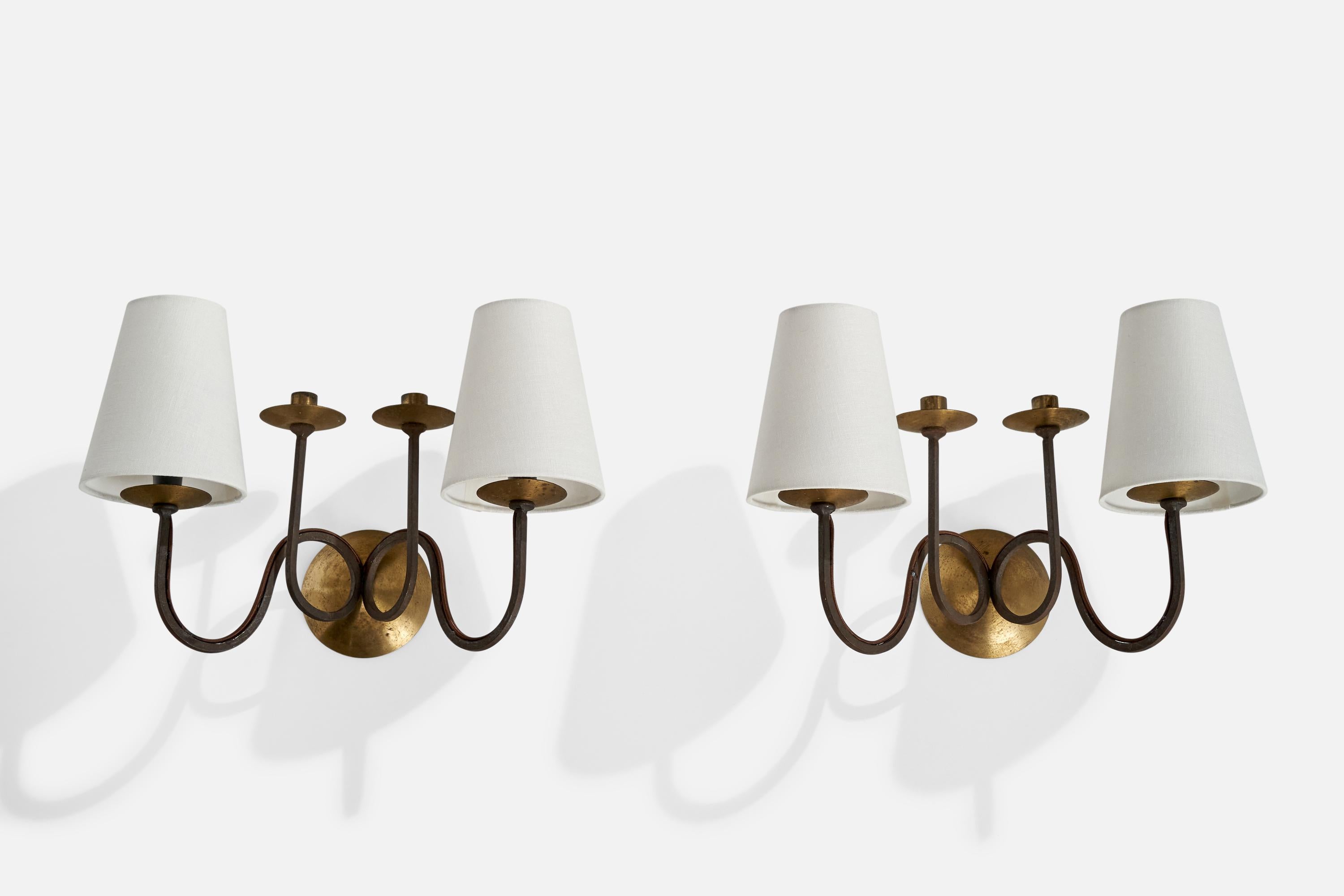 A pair of brass, black-painted iron and white fabric wall lights with candle holders designed and produced in France, c. 1940s.

Holds .75