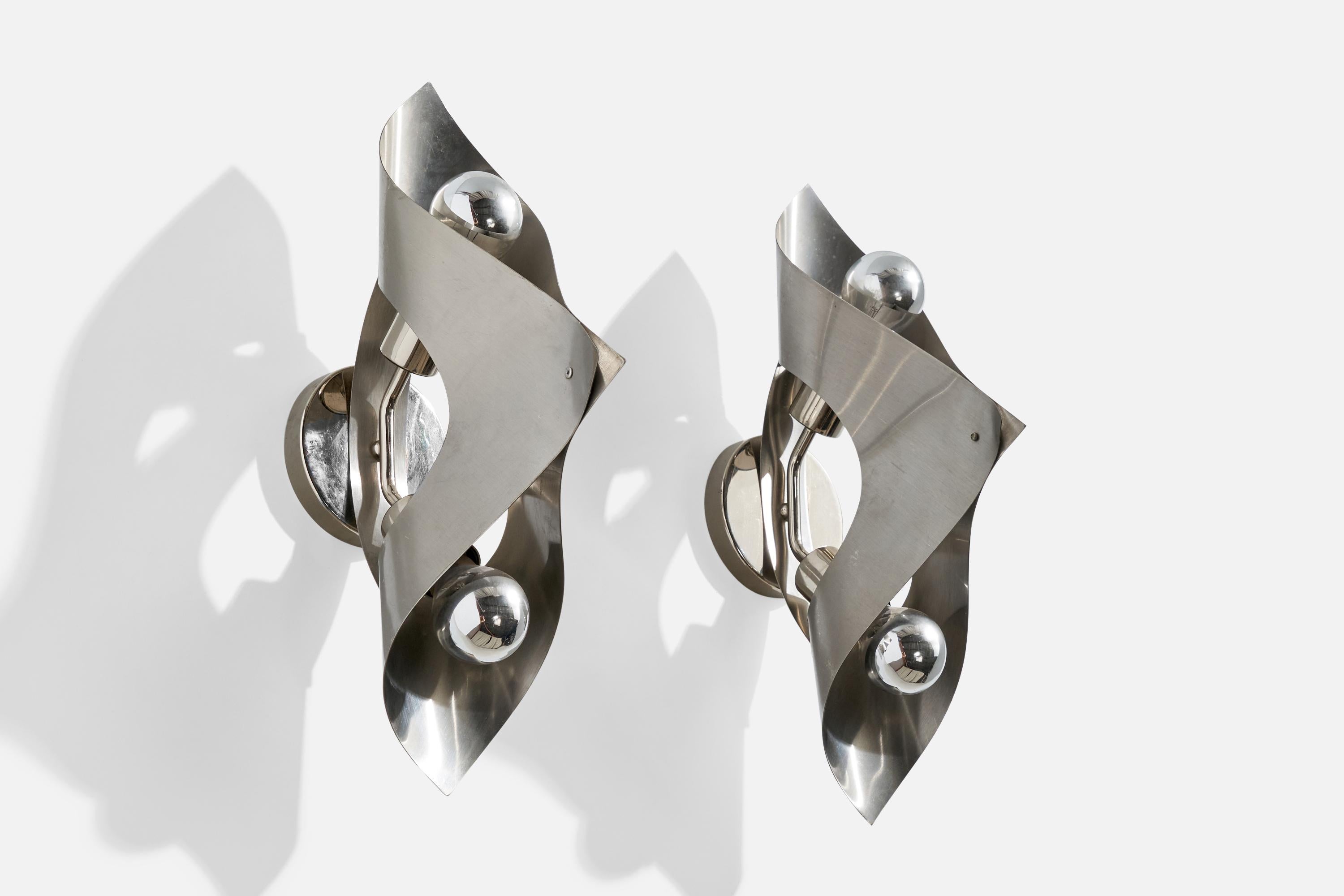 A pair of steel wall lights designed and produced in France, c. 1970s.

Overall Dimensions (inches):  19” H x  4.625” W x  10“D

Back Plate Dimensions (Inches): 4.625 ” H x 4.625” W x .75” D

Bulb Specifications: E-26 

Number of Sockets (per