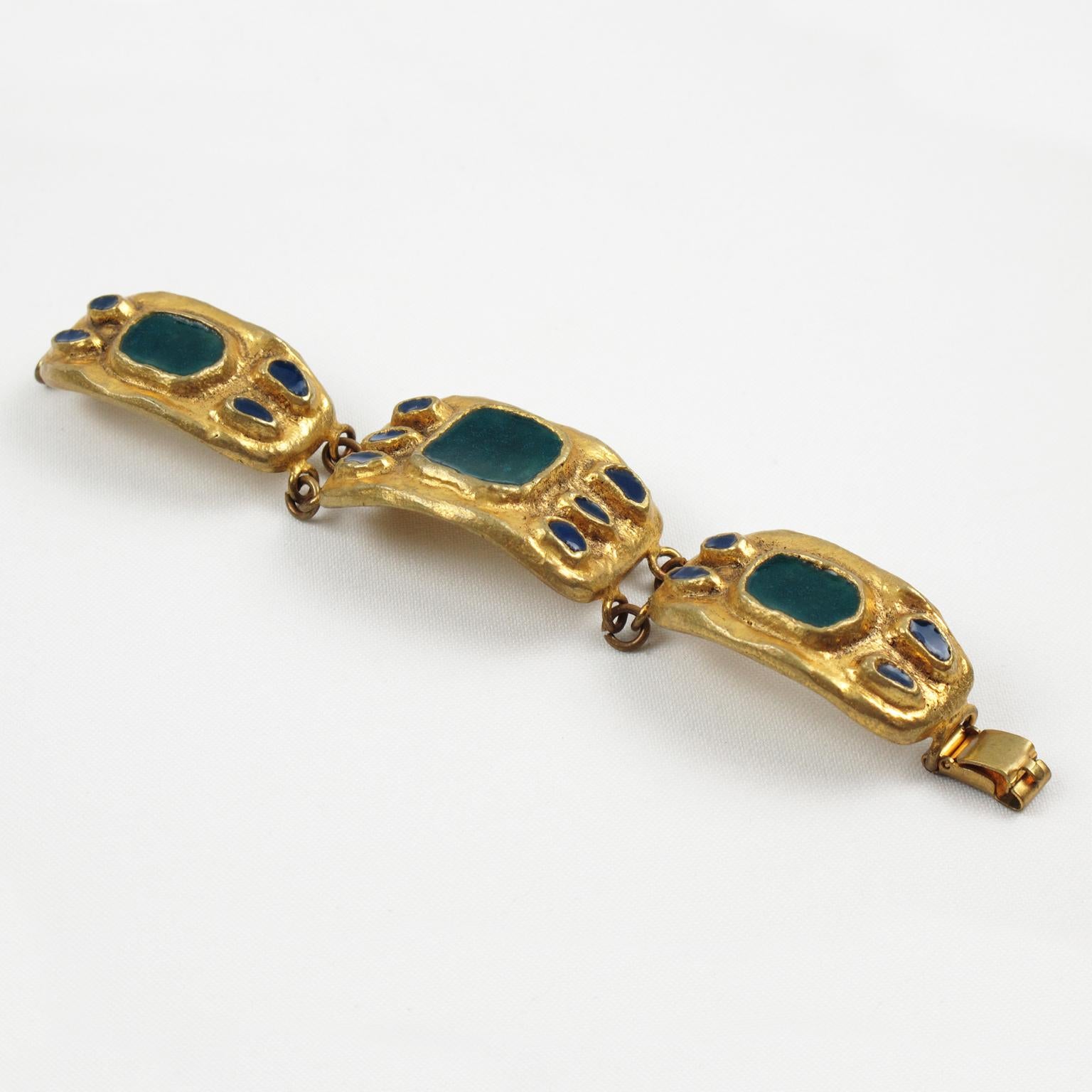 The French designer and artist Willy produced this exquisite mid-century 1950s link bracelet. The bracelet features geometric gilt bronze hand-made elements topped with thick enamel in turquoise-teal and navy blue colors. Locking clasp box to fasten