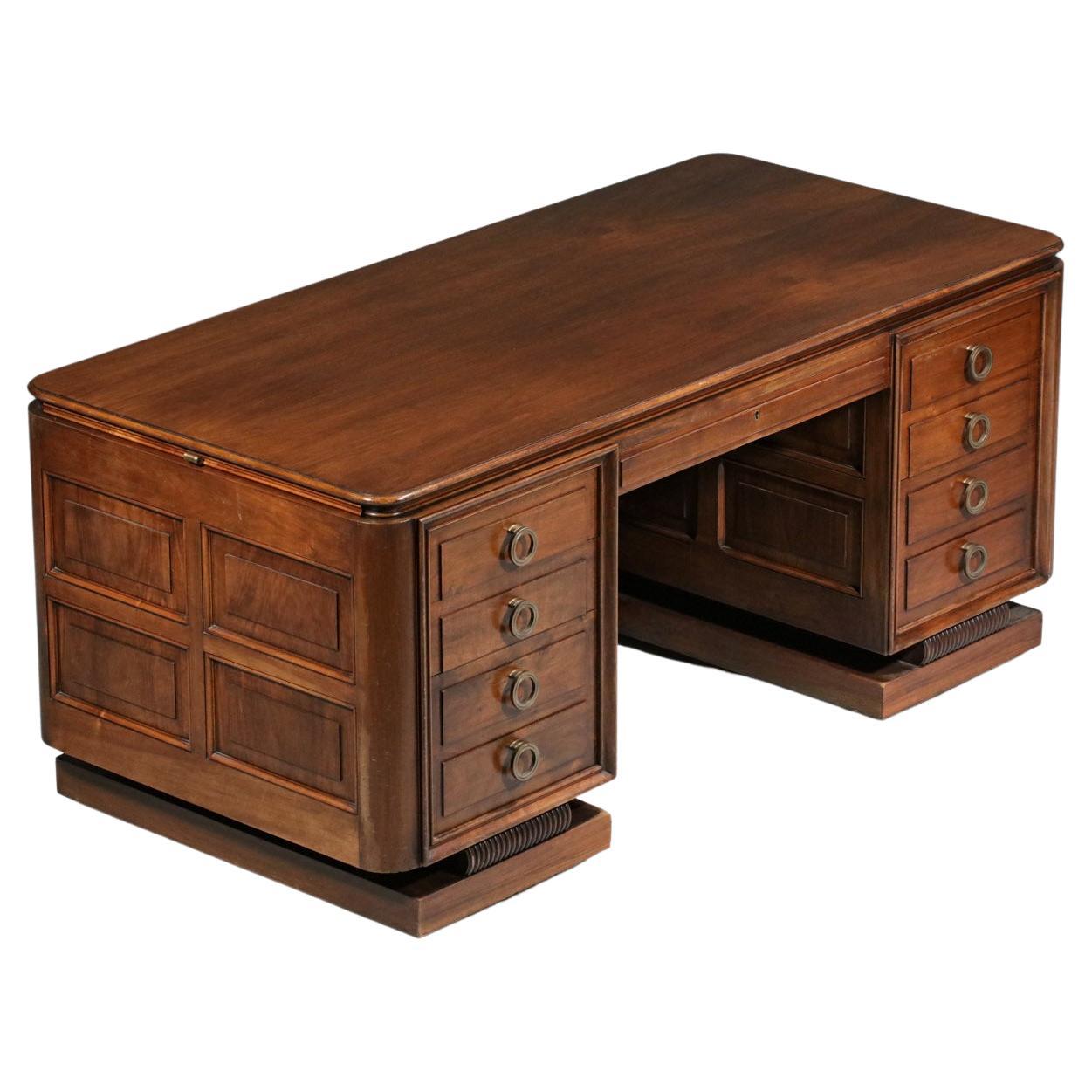Imposing art deco desk from the 50's in the taste of André Arbus's work. Structure in solid oak and veneer, brass handles. Very nice work of wood on the whole desk which takes the same design as the base. It is composed of four side drawers, a