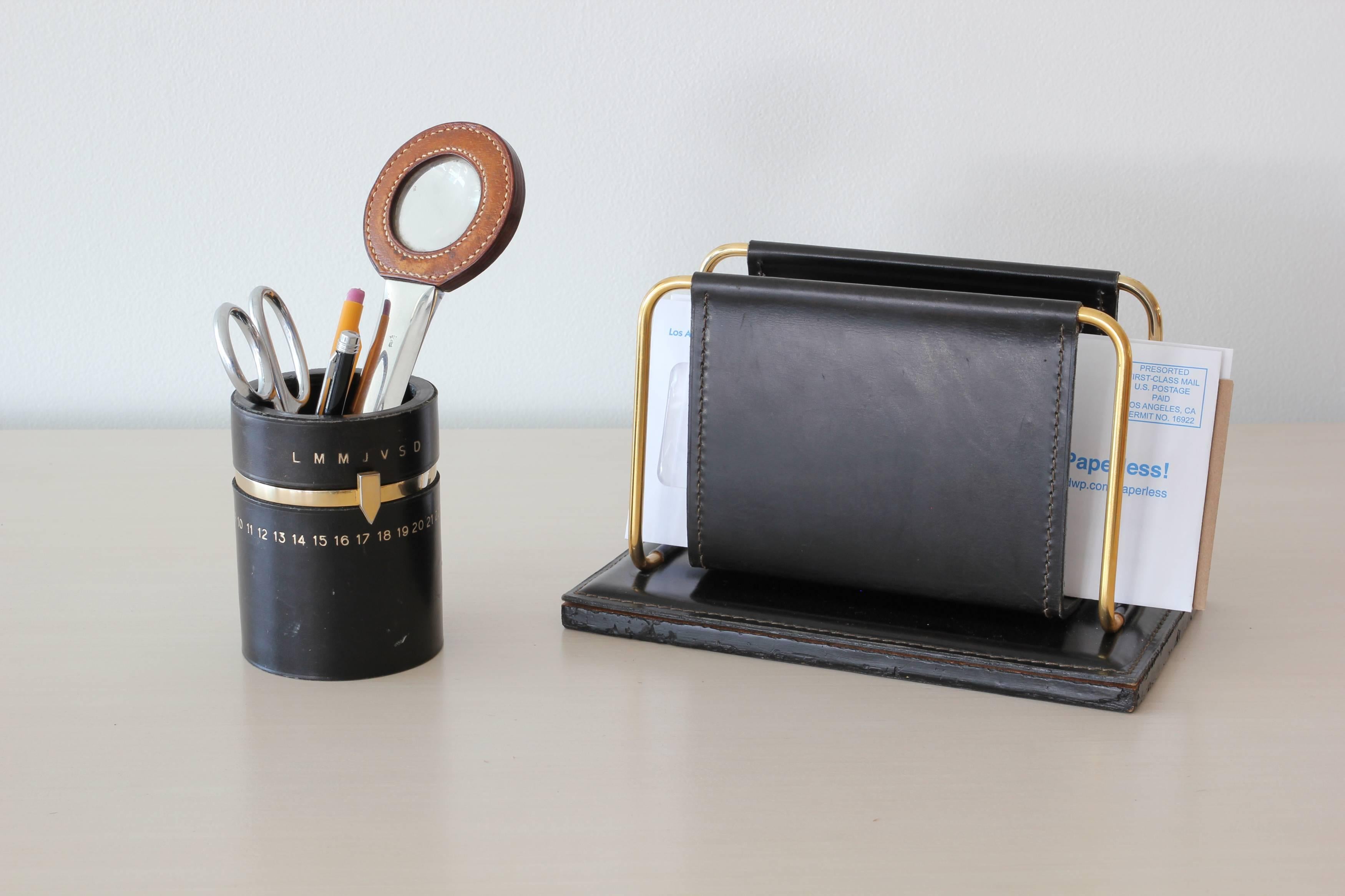 French black leather desk accessory in the style of Jacques Adnet. 
Fantastic pencil holder with days of the week and month in brass. 
 