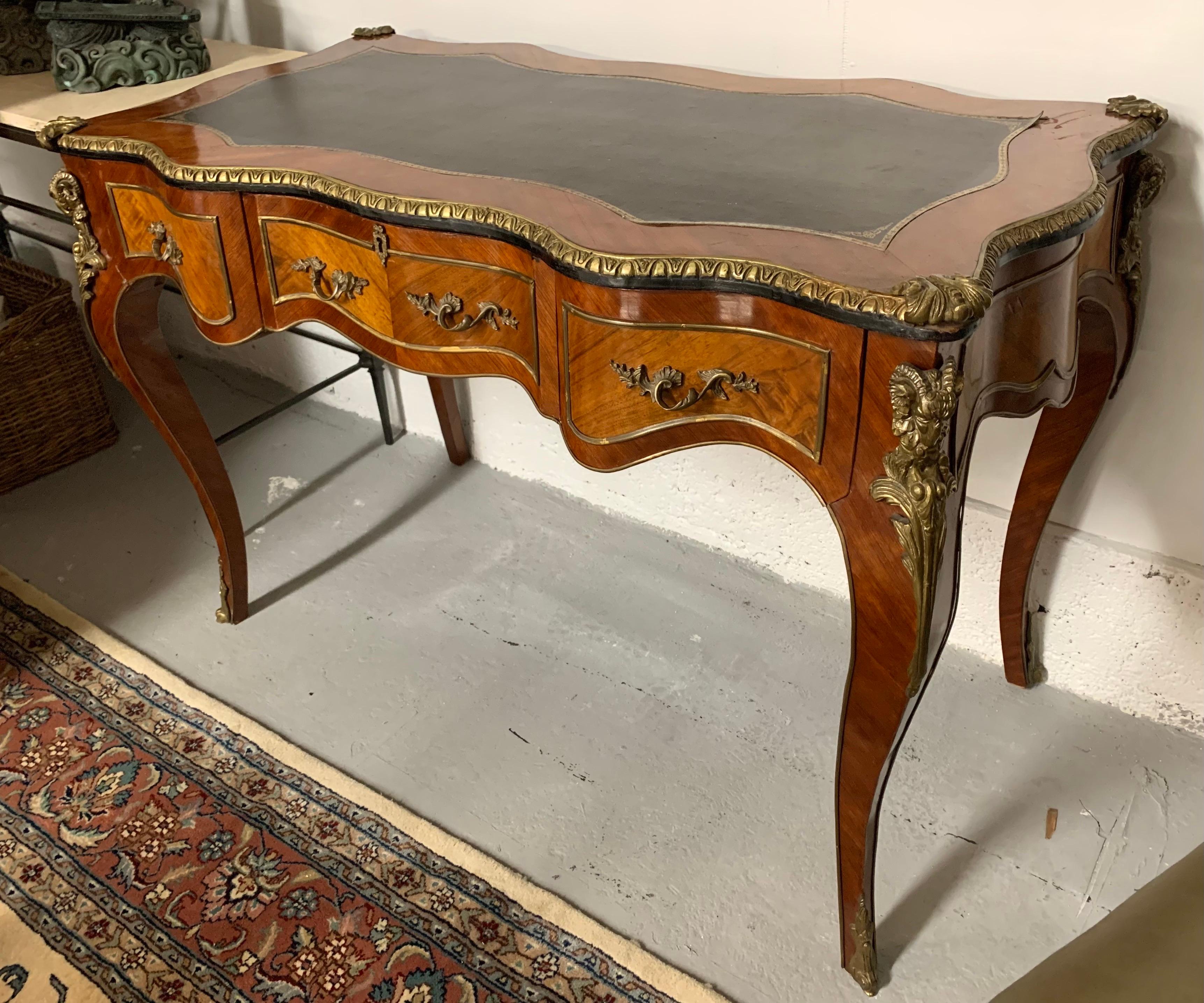 Stunning French Louis XV style three drawer desk/bureau plat with dore bronze mounts and leather writing surface. Looks great on all sides.
