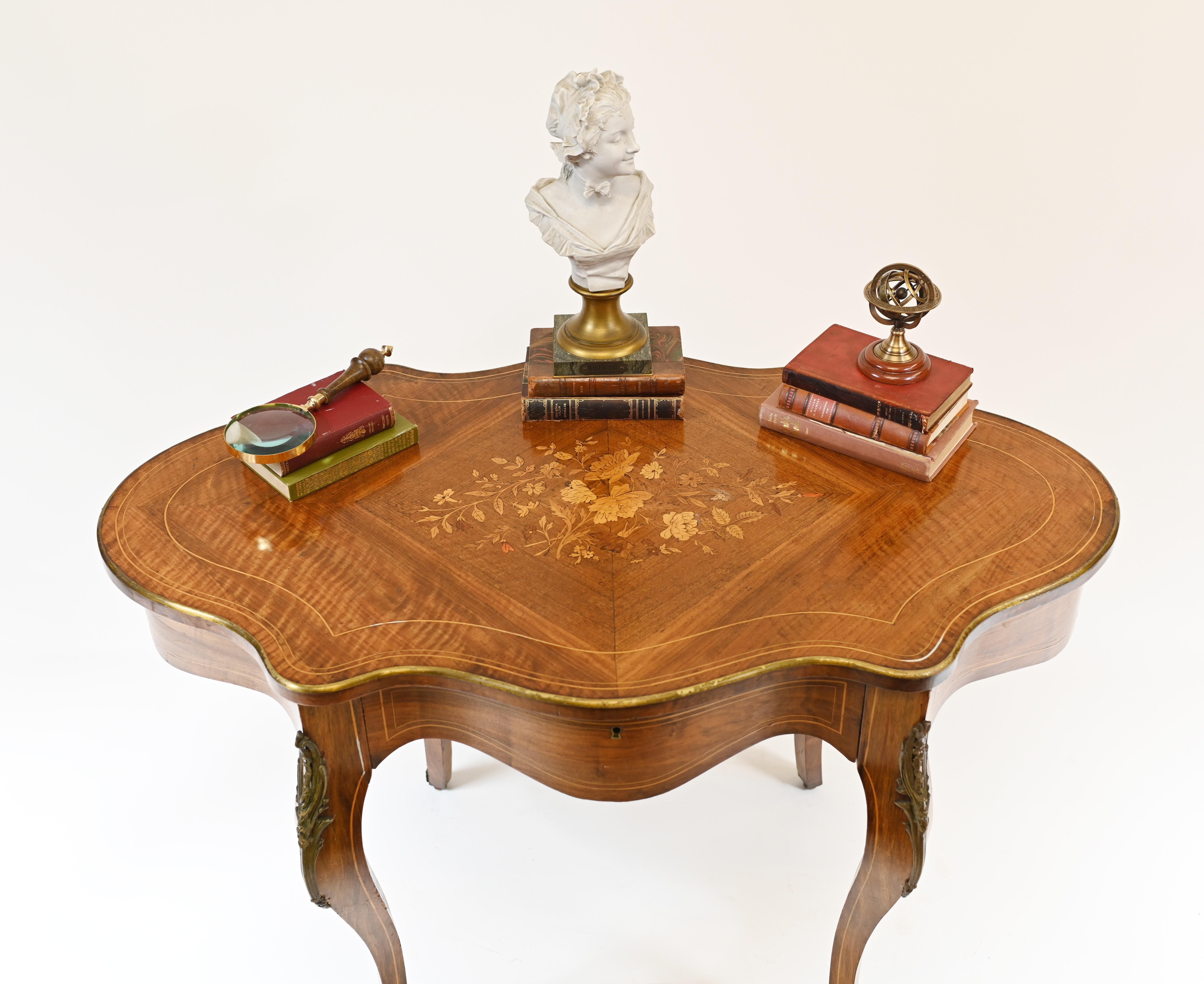 Elegant antique French desk or centre table 
Lovely shaped top with elegant top on cabriole legs
Original ormolu mounts
Circa 1880 
Inlay work very intricate showing floral motifs
Bought from a dealer on Marche Biron at Paris antiques